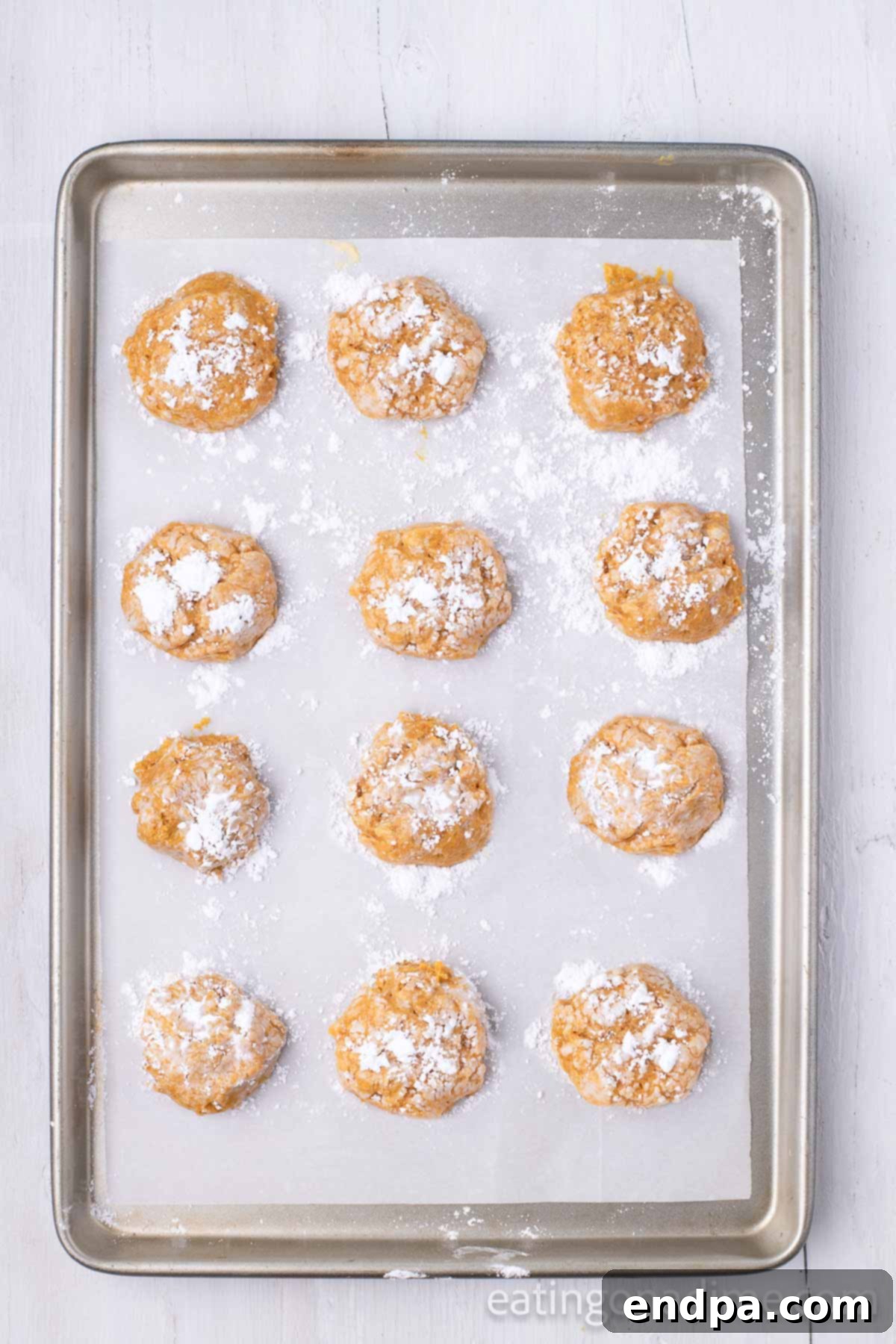 Cookies dipped in powdered sugar and placed on baking sheet. 