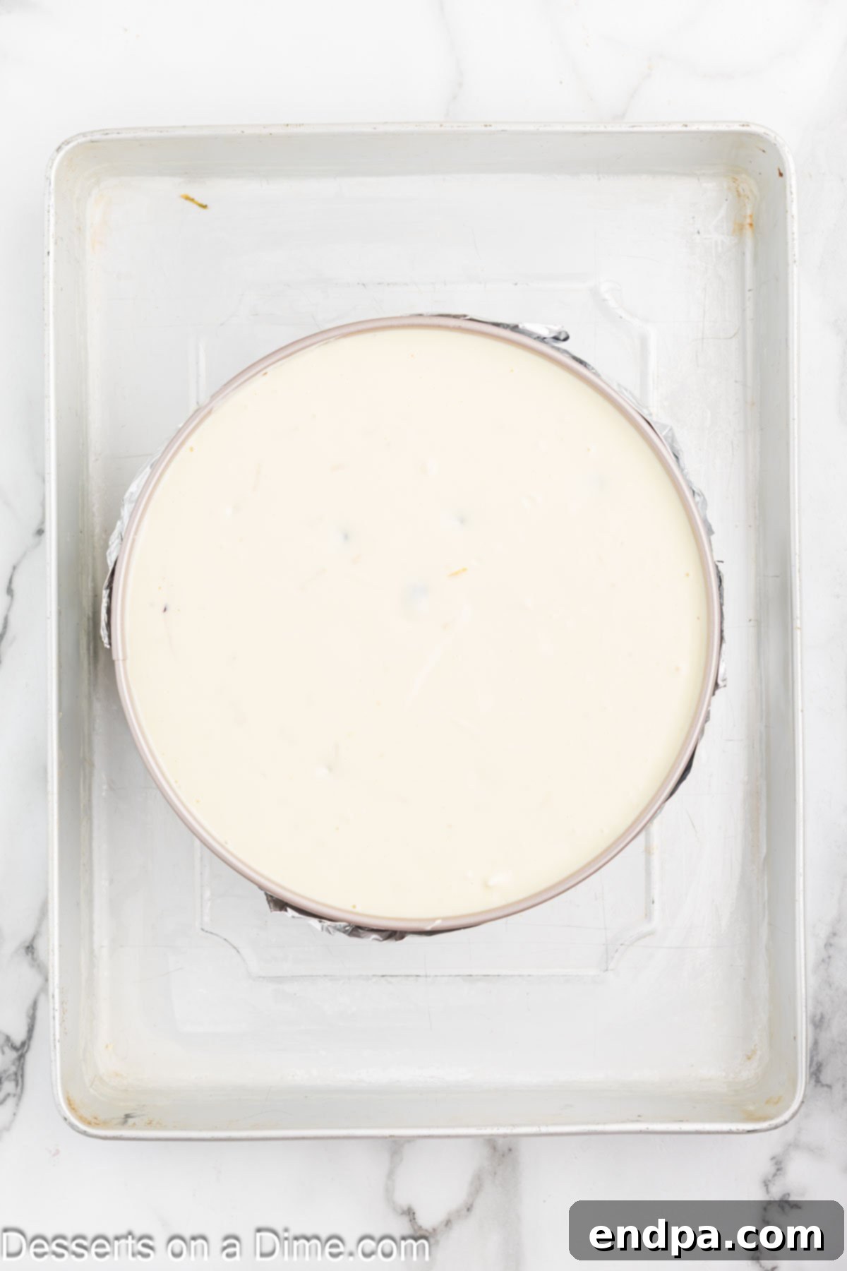 Heavenly Lemon Blueberry Cheesecake 7 The smooth lemon blueberry cheesecake filling is poured into the pre-baked graham cracker crust in a springform pan, which is then placed inside a larger roasting pan for a water bath.