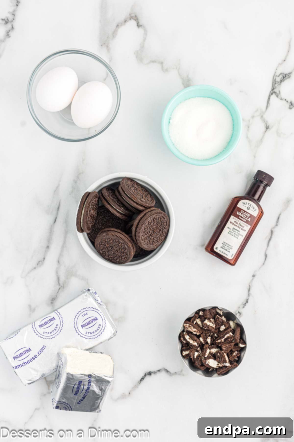 Ingredients laid out: Oreo cookies, softened cream cheese, granulated sugar, vanilla extract, eggs.