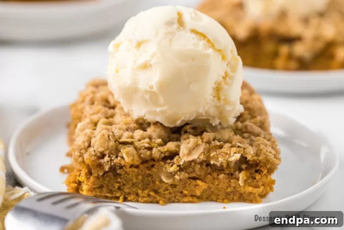 Autumn Pumpkin Crumble 2 Pumpkin crisp topped with a generous scoop of melting vanilla ice cream, garnished with a sprinkle of cinnamon, ready to be served on a cozy fall evening.