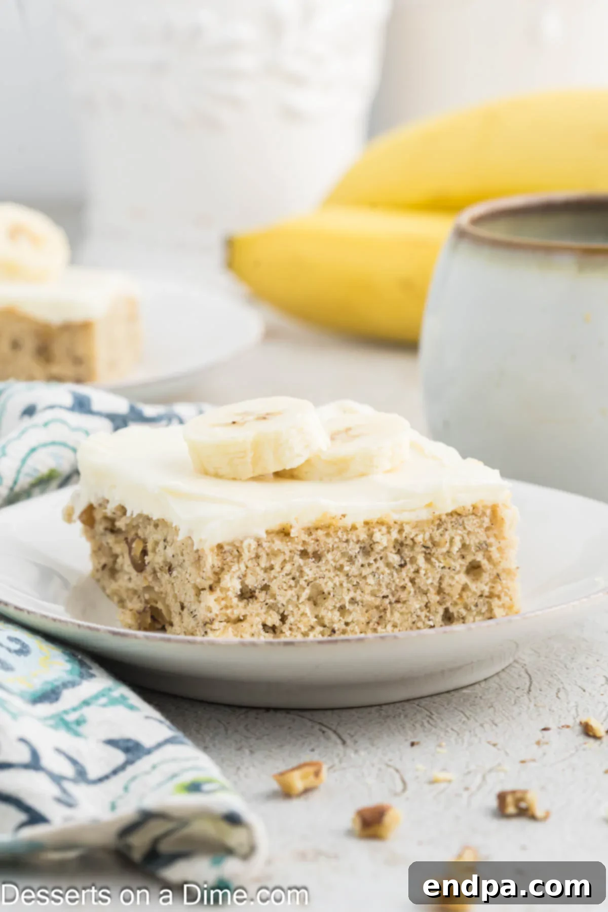 Ultimate Banana Bars 12 Several banana bars, perfectly sliced and frosted, served on a pristine white plate, garnished subtly.