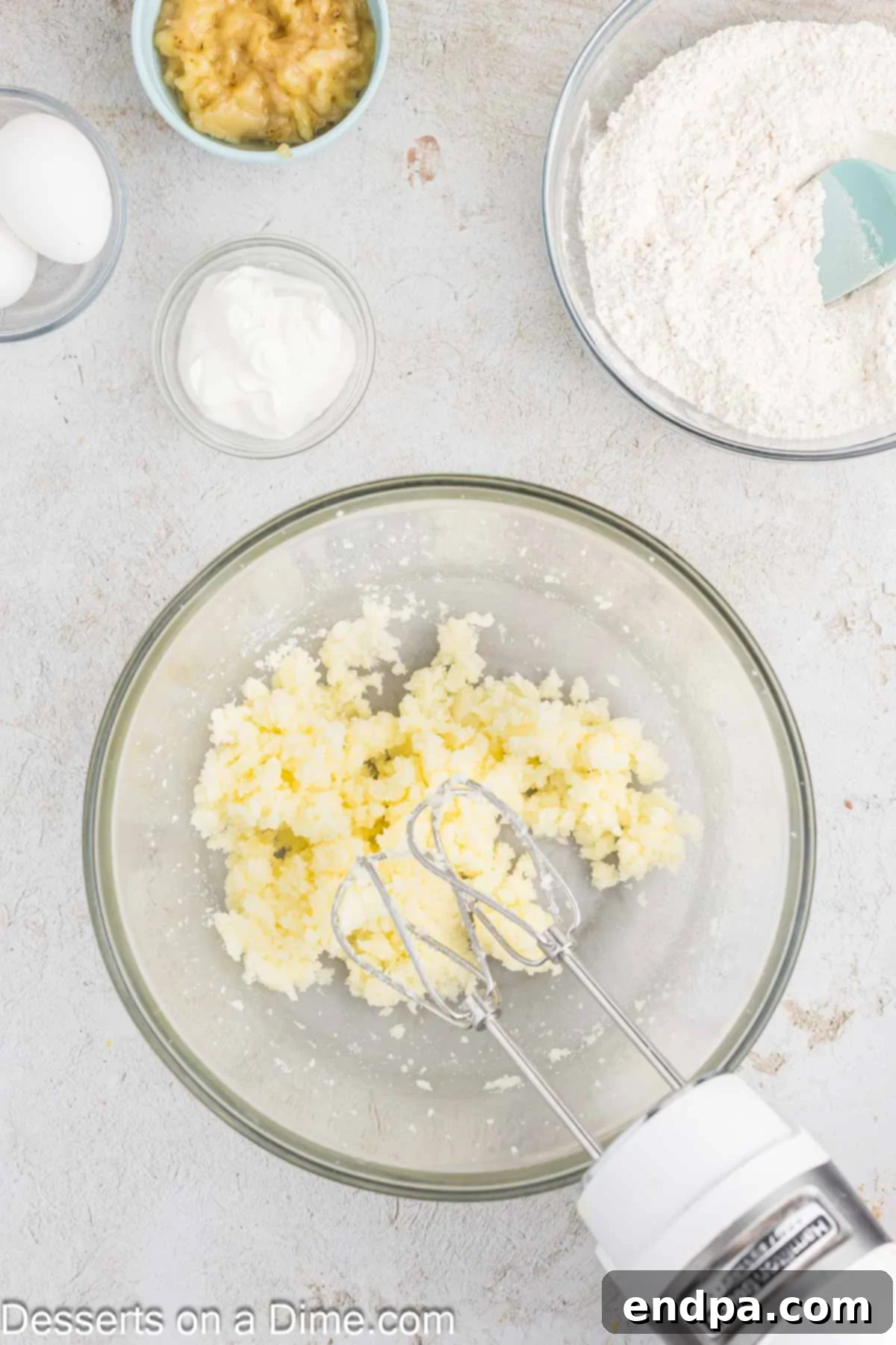 Ultimate Banana Bars 4 Softened butter and granulated sugar being creamed together in a mixing bowl until light and fluffy.