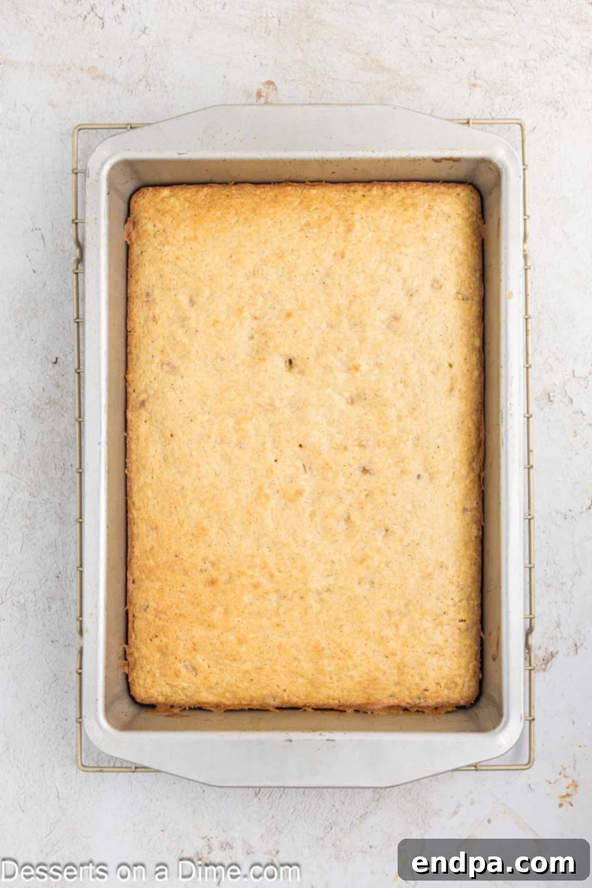 Ultimate Banana Bars 7 Baked banana bars cooling in the pan after being removed from the oven, showing a golden-brown top.