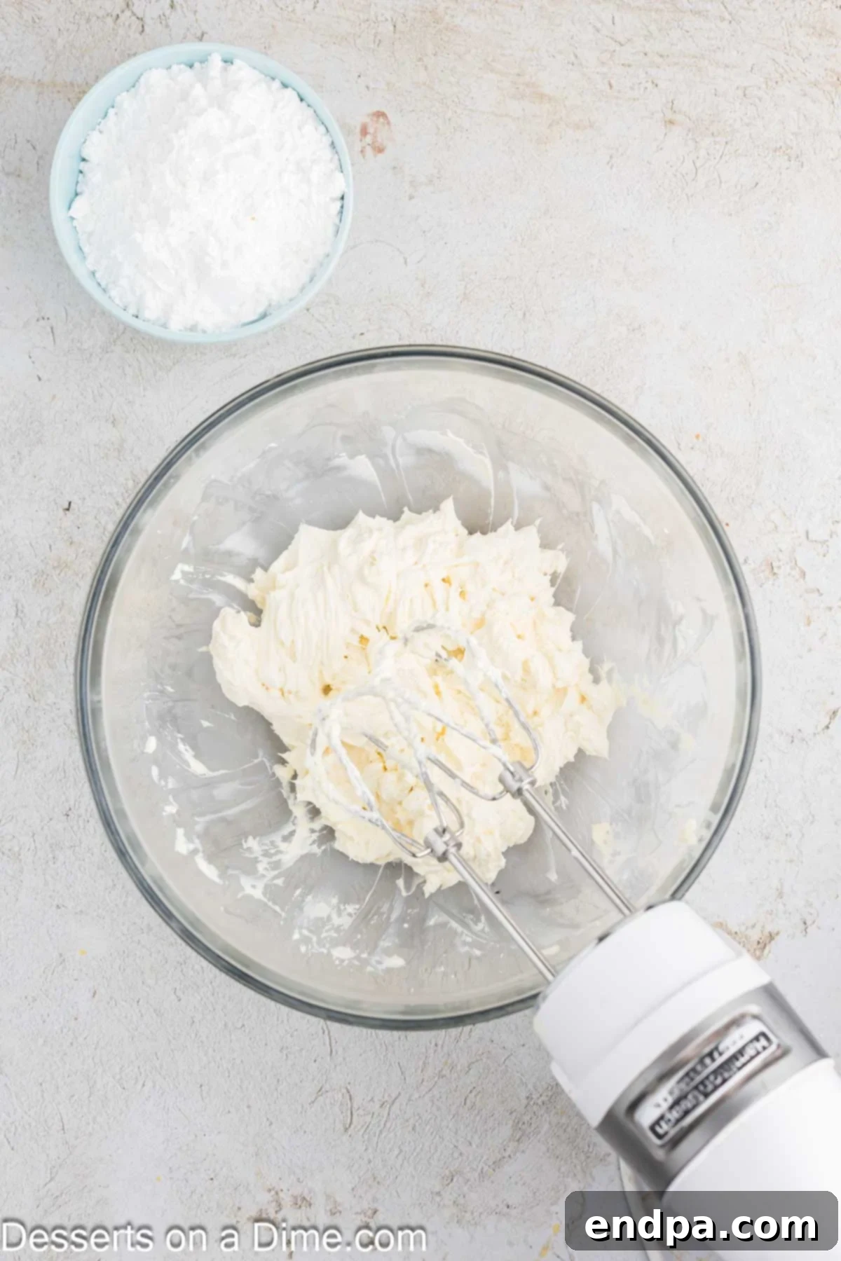 Ultimate Banana Bars 8 Softened butter and cream cheese being beaten together in a mixing bowl until smooth and combined for the frosting.