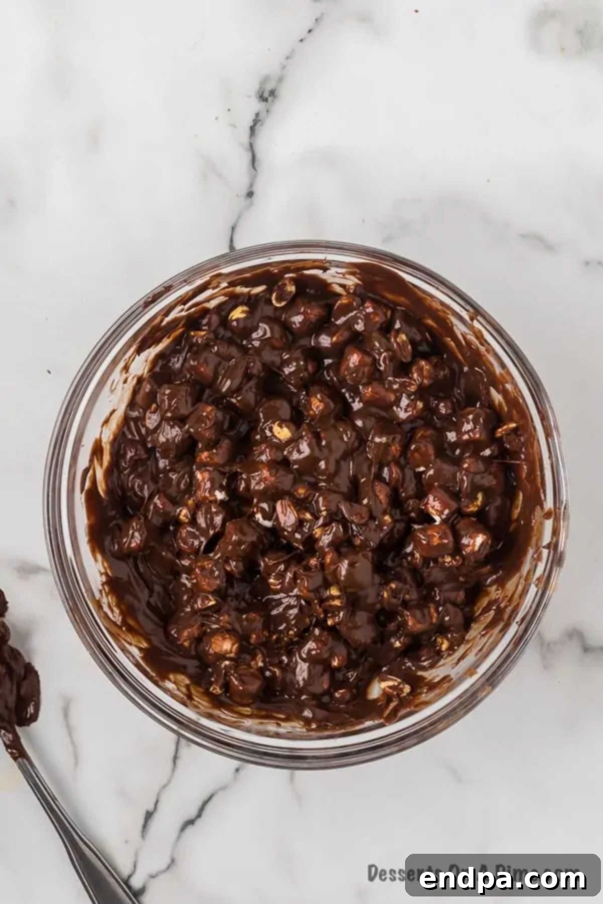 Fudge mixture combined together. The complete Rocky Road fudge mixture, with marshmallows and peanuts evenly distributed, ready to be poured into the pan.