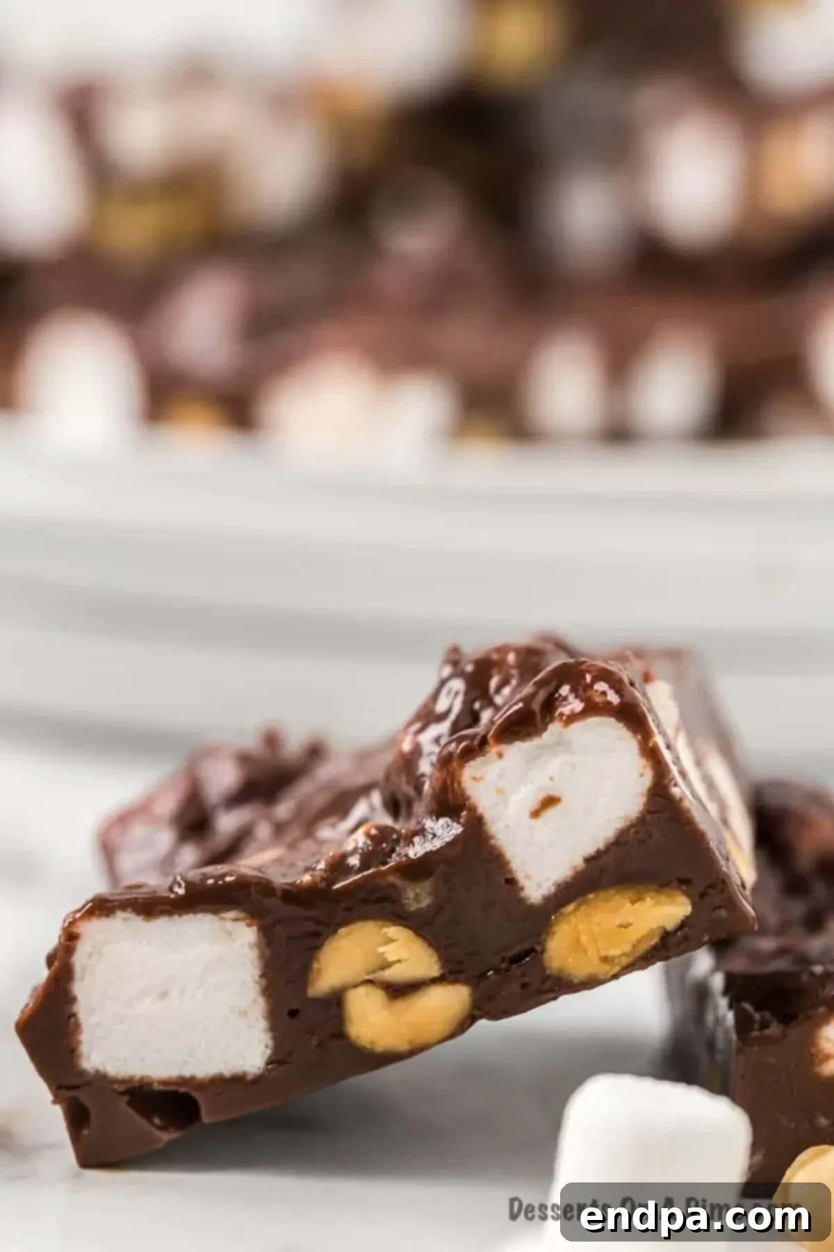 Rocky Road Fudge cut into slices. A beautifully arranged stack of homemade Rocky Road Fudge slices, highlighting the irresistible combination of chocolate, marshmallows, and peanuts.