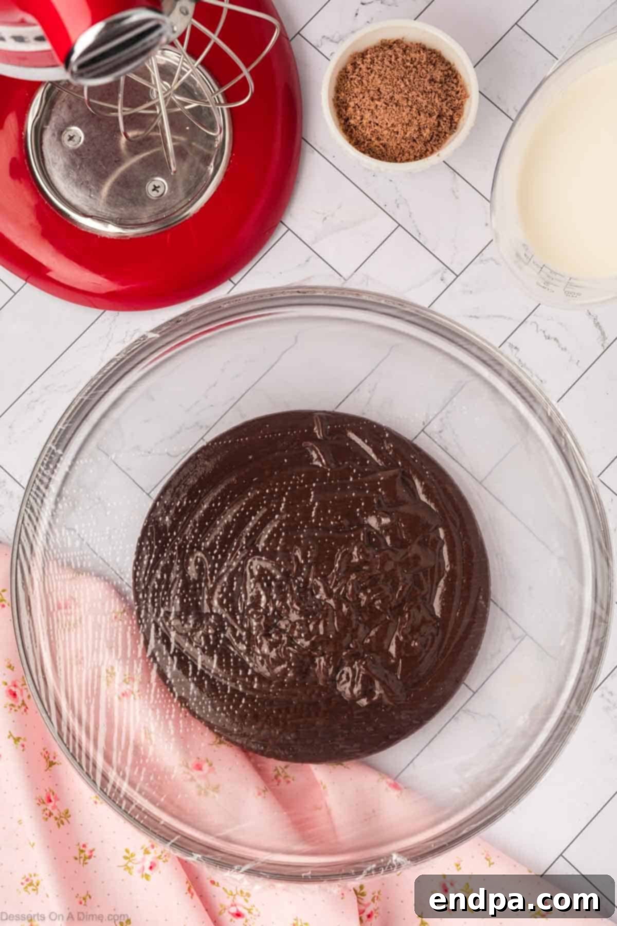 Chocolate mixture poured into a bowl and covered with plastic wrap.