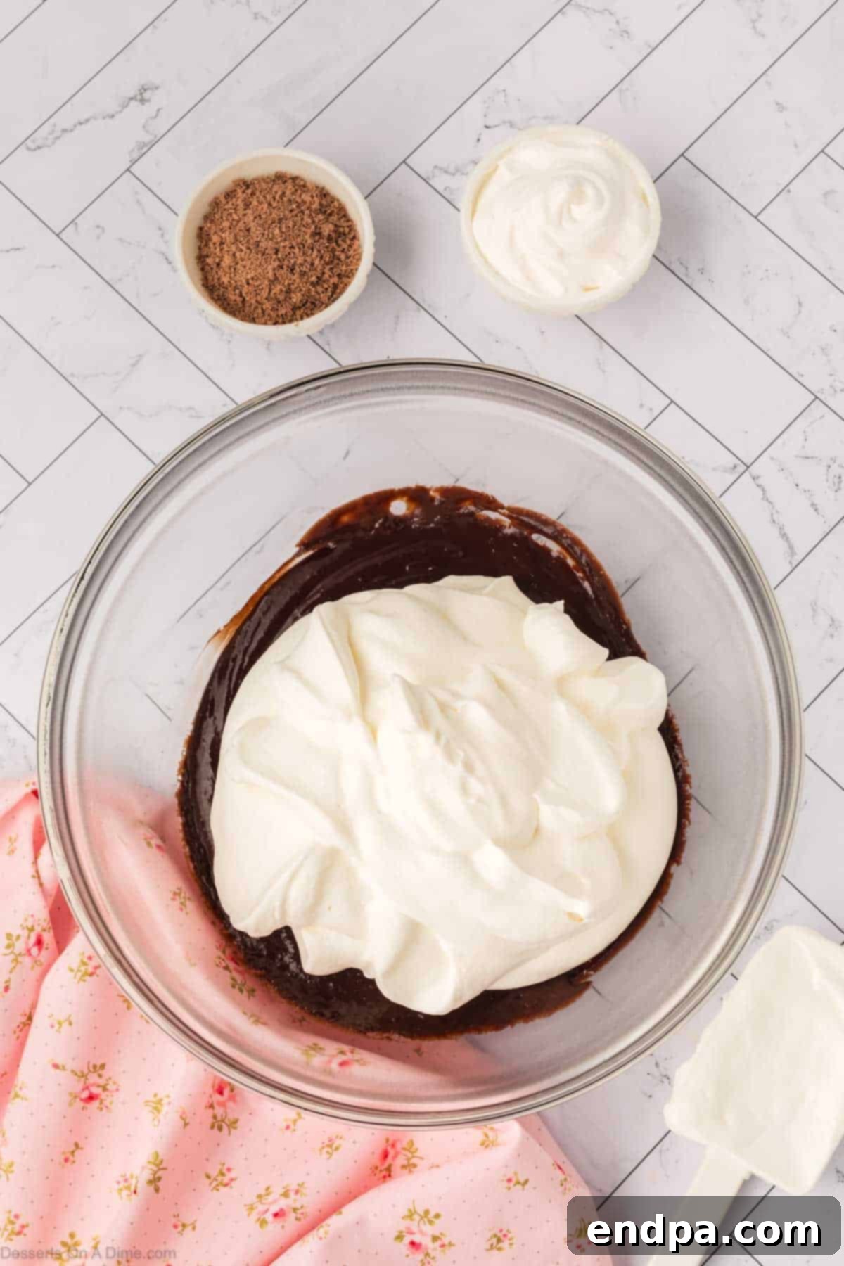 Whipped cream being added to the cooled chocolate mixture.