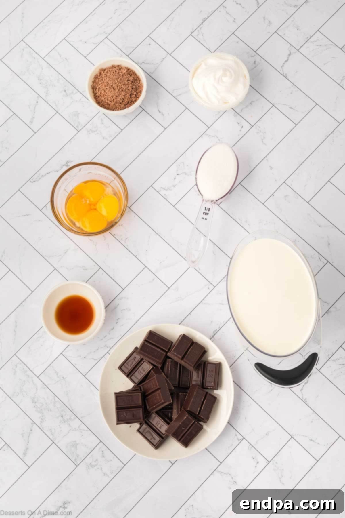 Ingredients for chocolate mousse - egg yolks, sugar, heavy cream, vanilla, chocolate laid out.