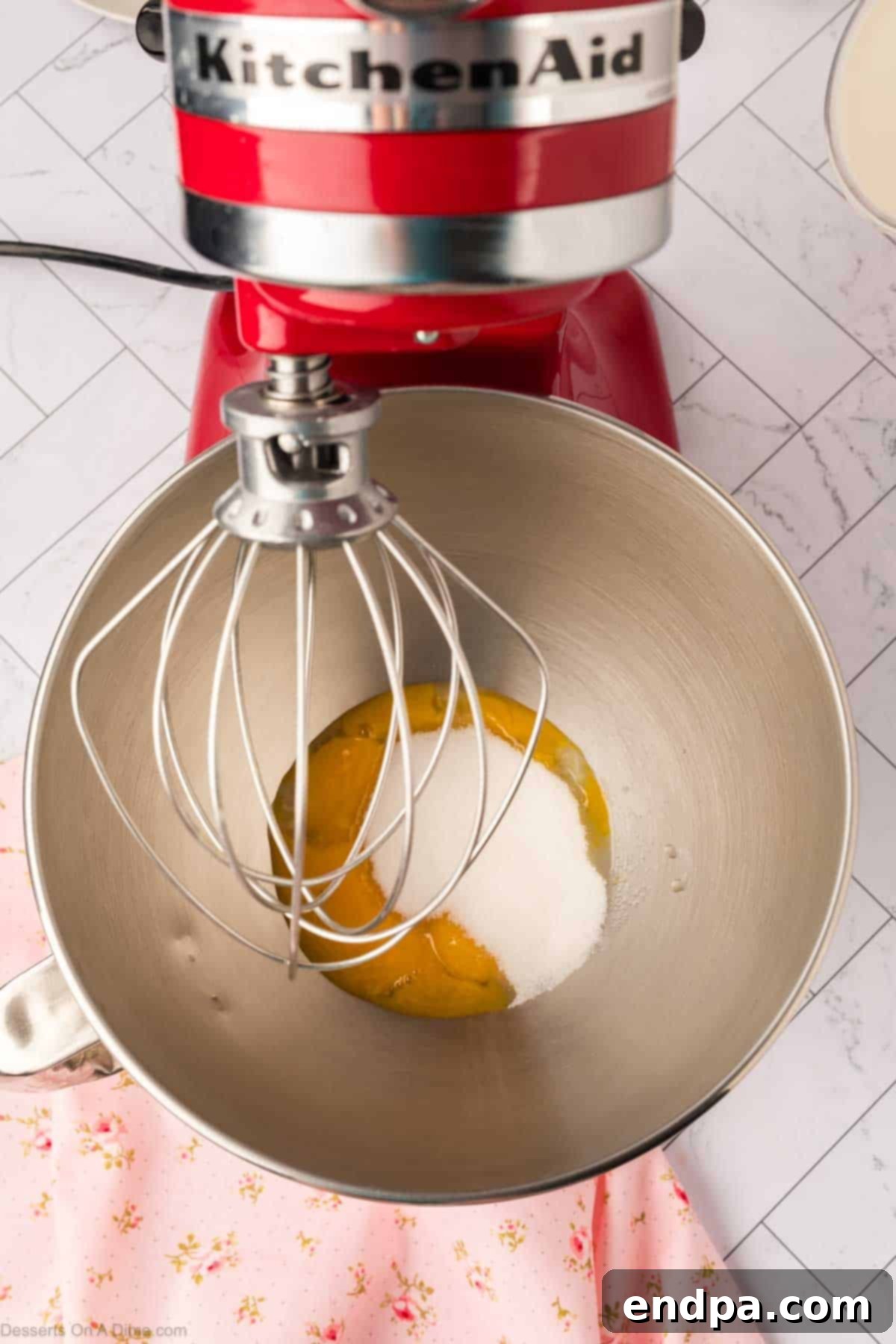 Egg yolks and sugar in mixing bowl being beaten.