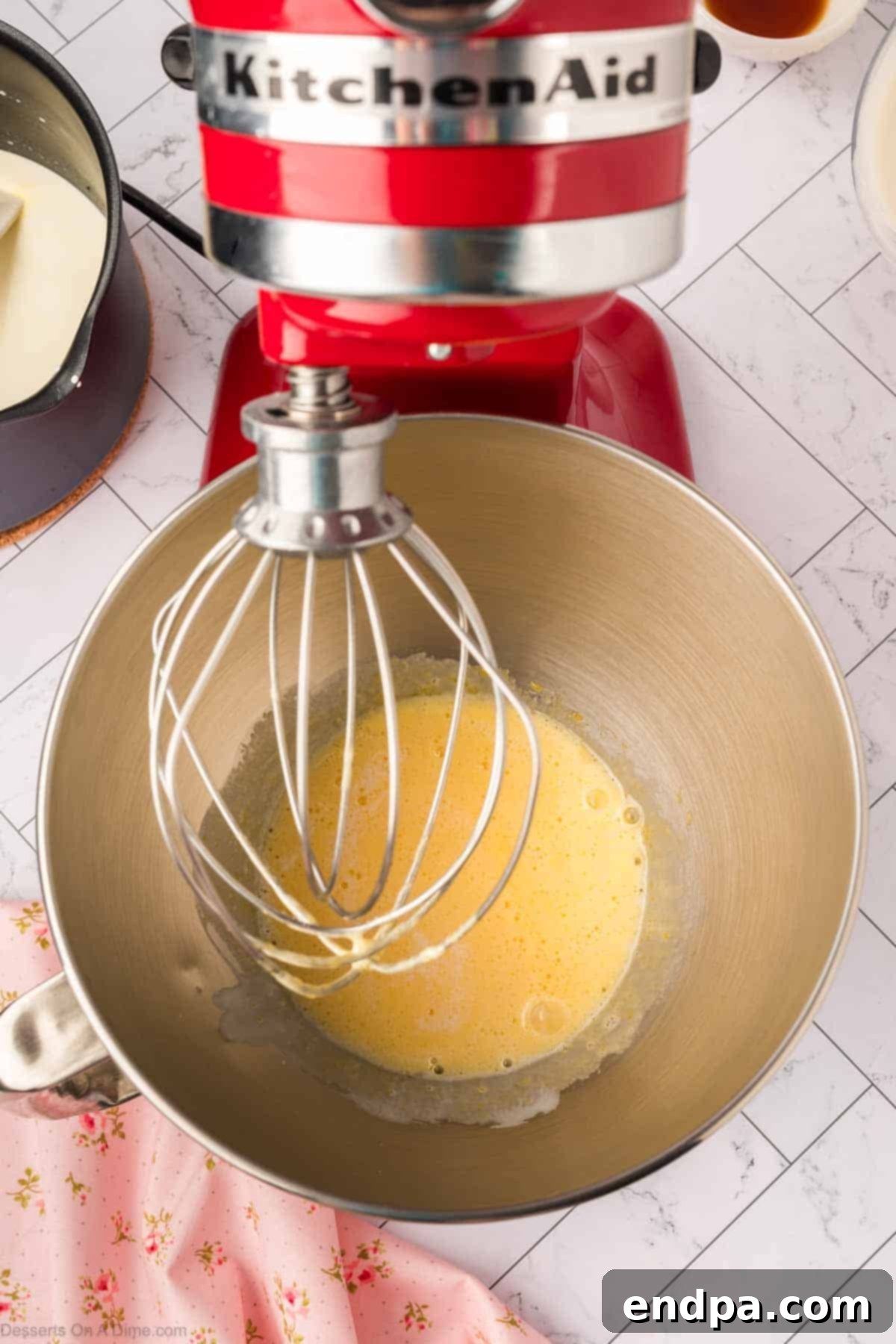 Warm cream being whisked into the egg mixture.