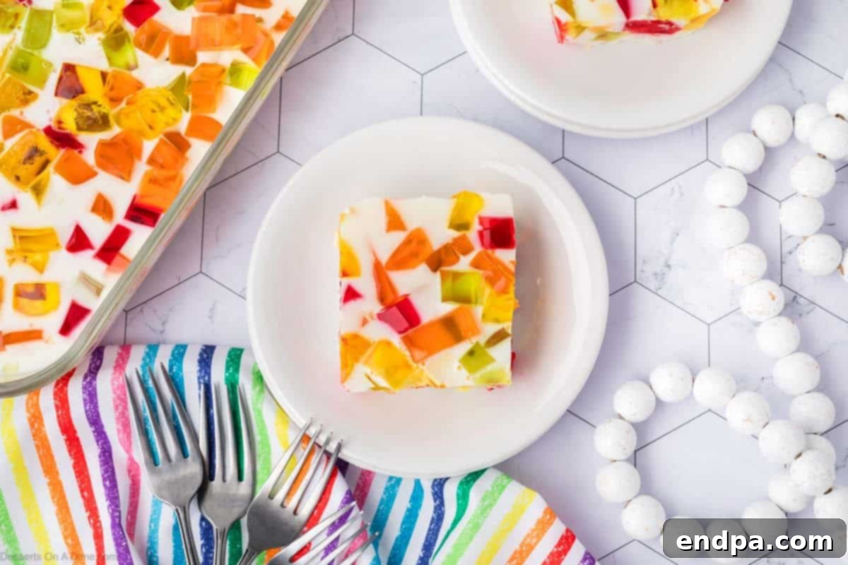 Vibrant Mosaic Gelatin 2 Broken glass jello cut into squares on a white plate.