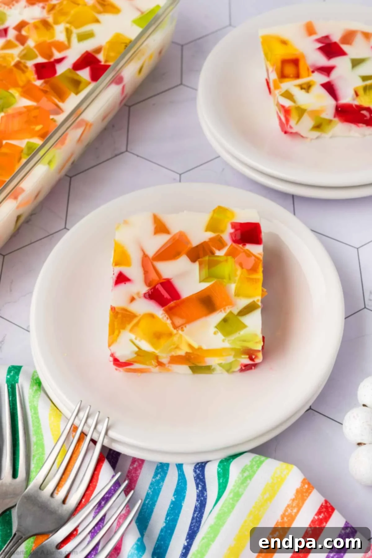 Vibrant Mosaic Gelatin 11 Slice of Broken Glass jello on white plate.