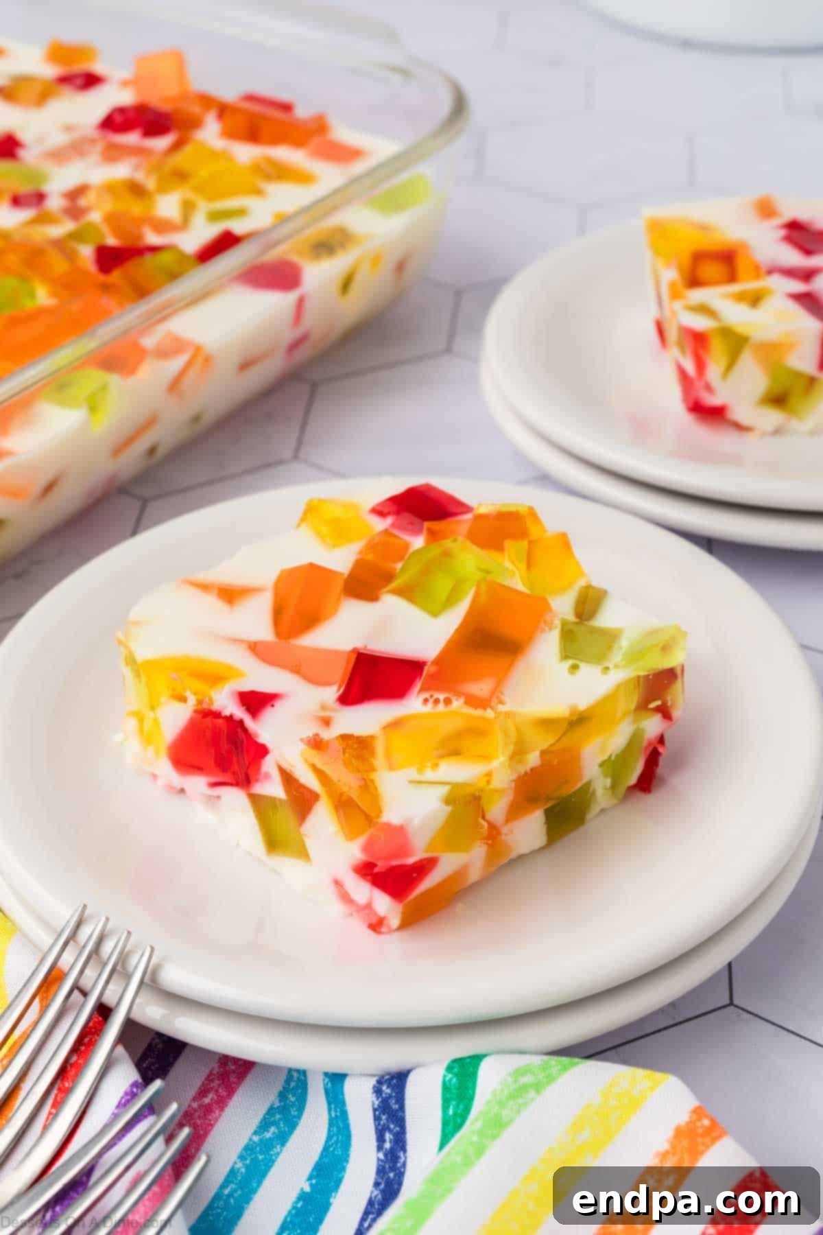Vibrant Mosaic Gelatin 12 Slice of Broken Glass jello on white plate.