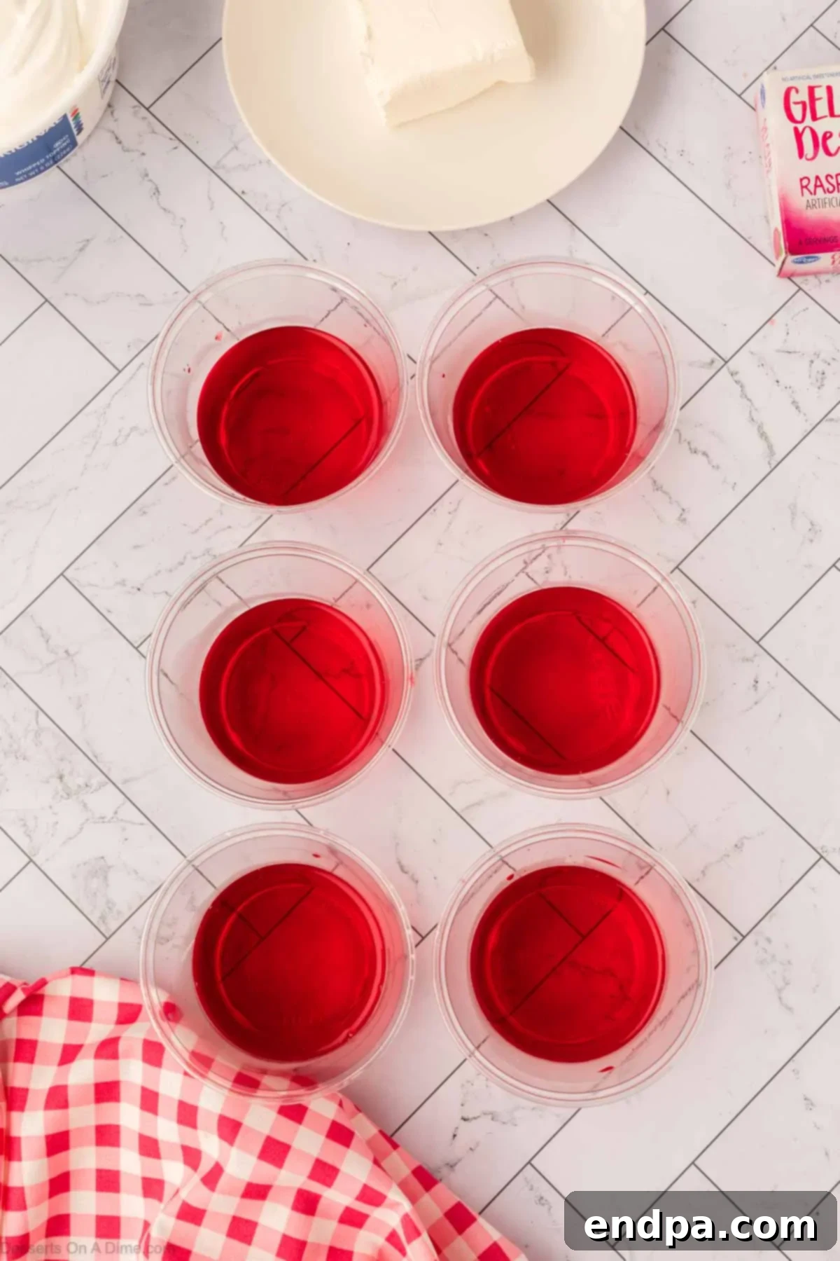 Layered Gelatin Delight 5 Individual serving cups filled with the initial layer of set Jello.