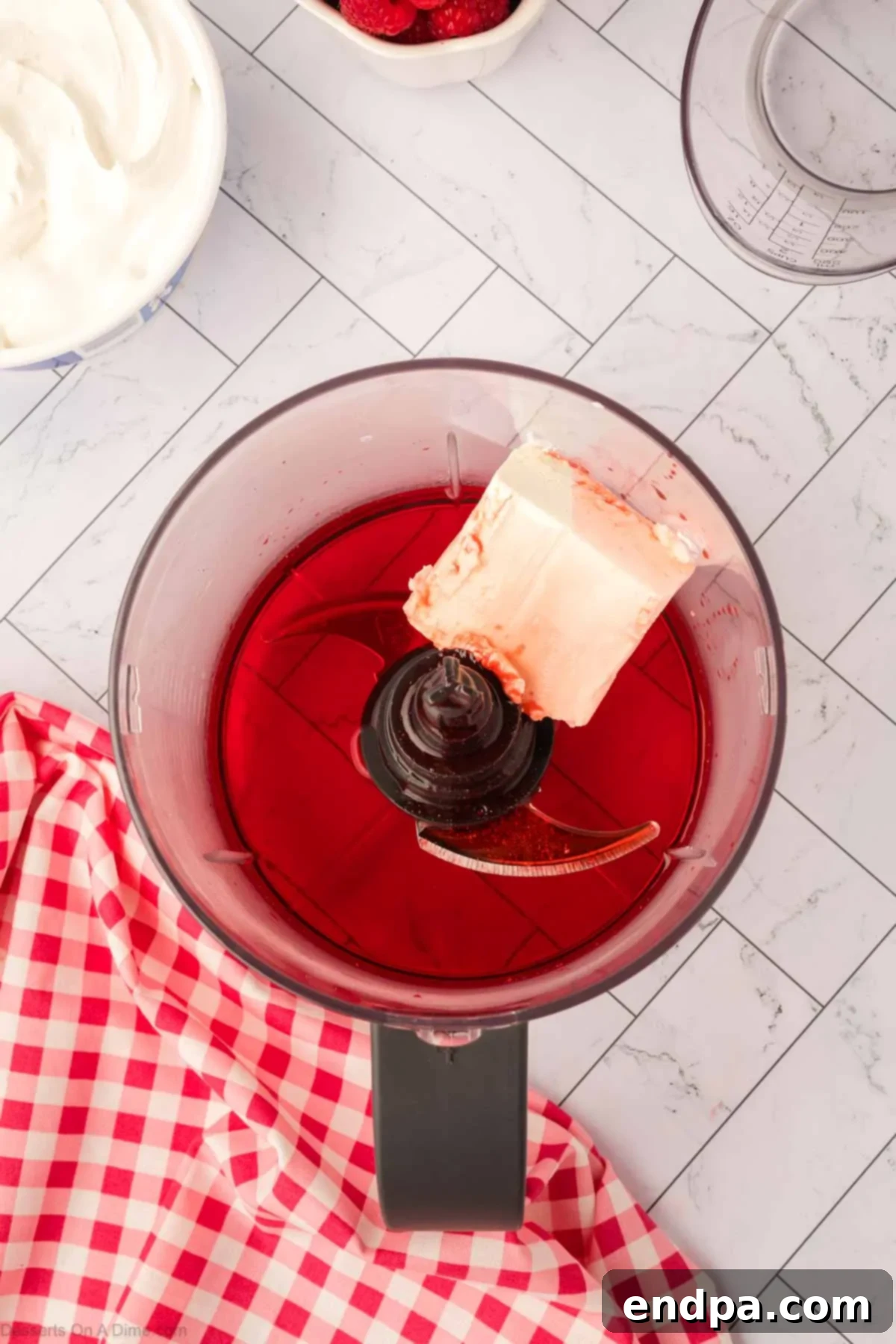 Layered Gelatin Delight 6 Cream cheese and dissolved Jello mixture being added to a food processor for blending.