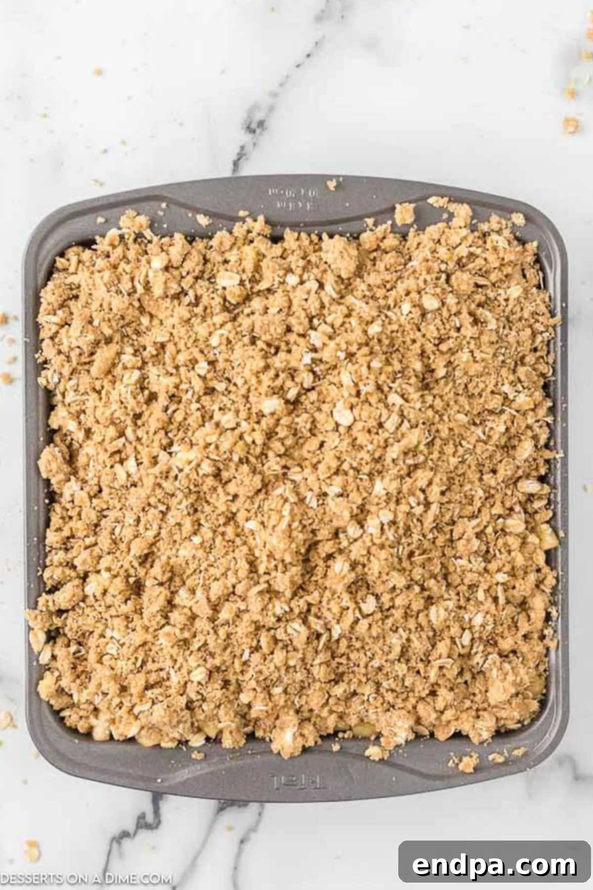 Buttery Oat Apple Crisp 9 Crumbly topping sprinkled evenly over the apple mixture in the baking pan.