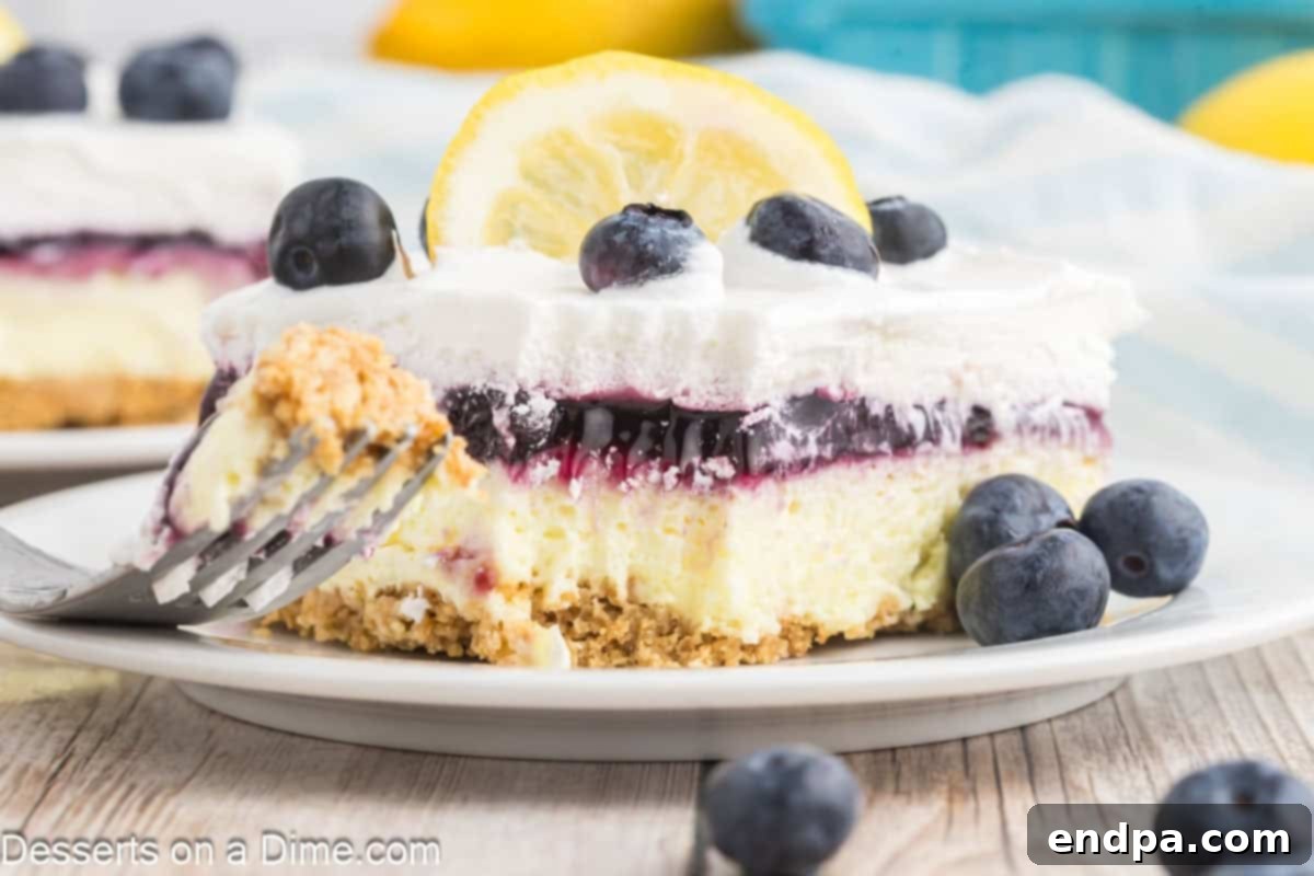 Lemon Blueberry Delight sliced and served on white plate with a fork.