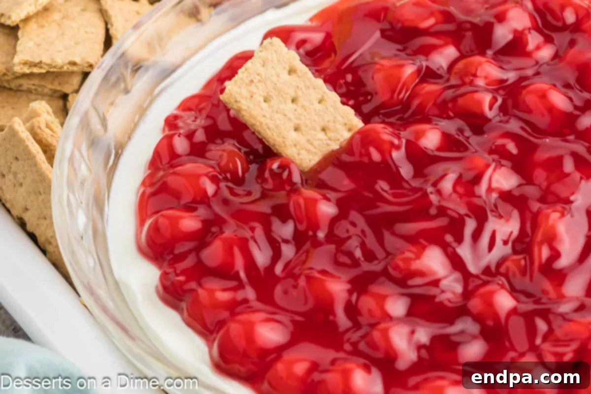 Luscious Cherry Cheesecake Dip 2 Cherry Cheesecake Dip in a dish with graham crackers, ready to be served.