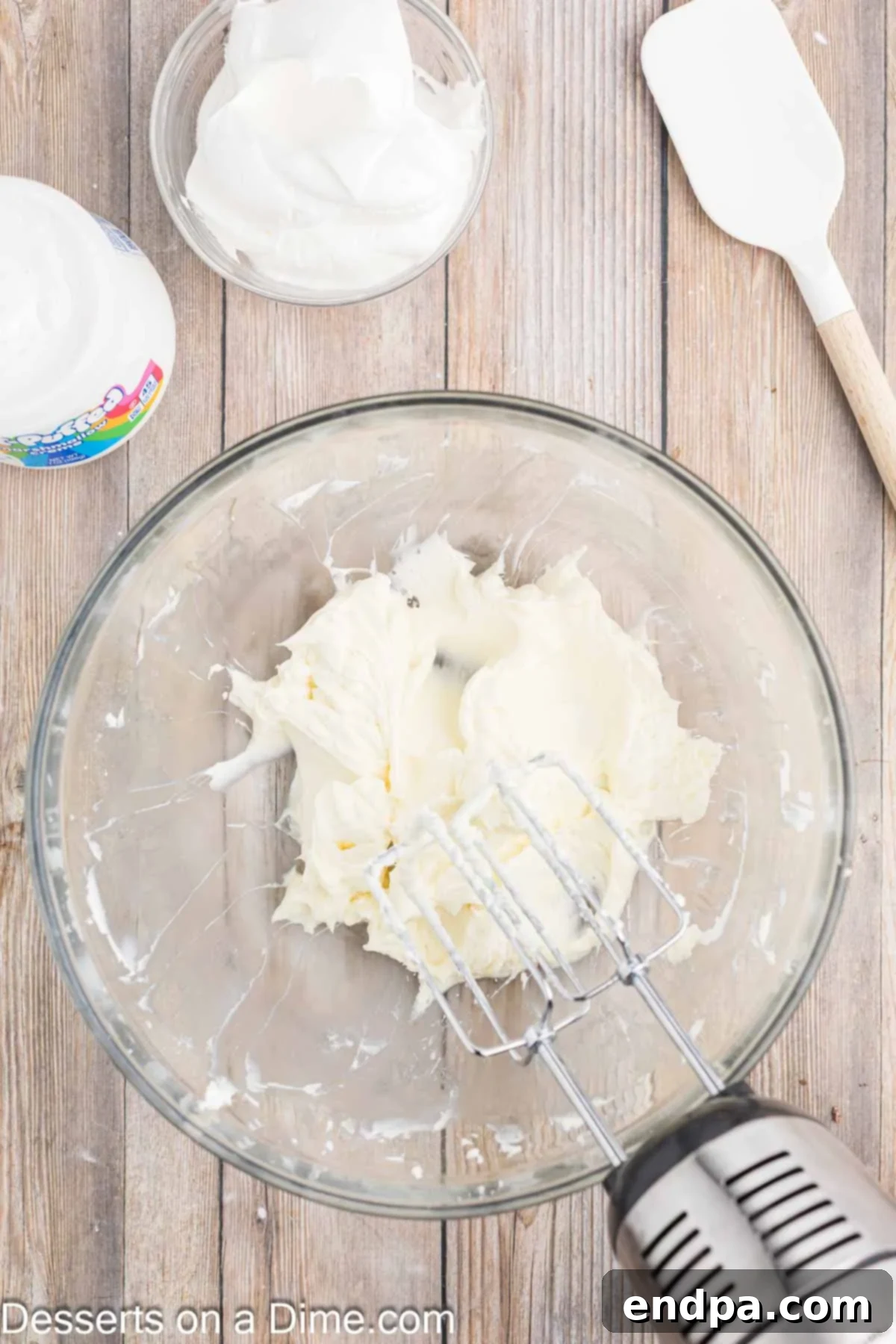 Luscious Cherry Cheesecake Dip 5 Powdered sugar and vanilla extract being added to the beaten cream cheese mixture.