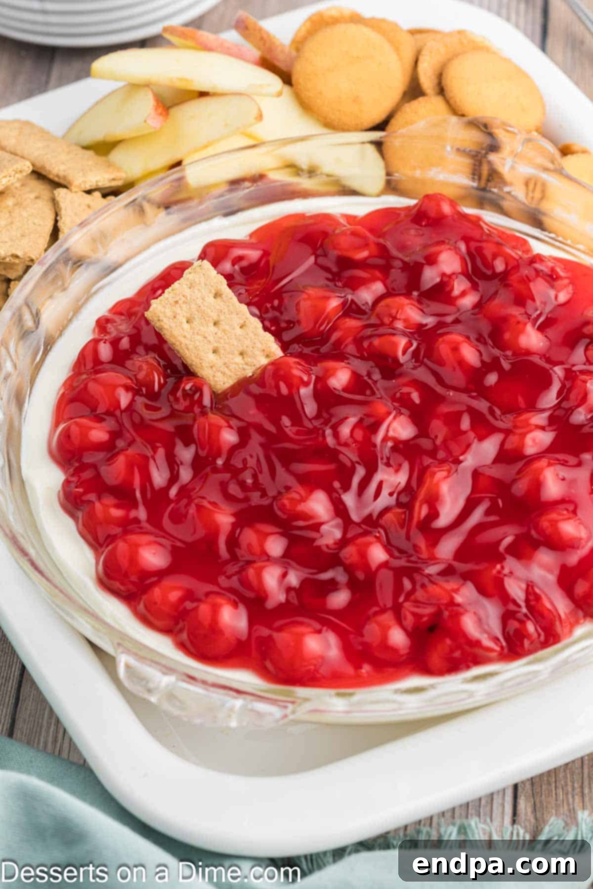Luscious Cherry Cheesecake Dip 8 Close-up of Cherry Pie Filling elegantly spread over the creamy cheesecake mixture in a glass dish.