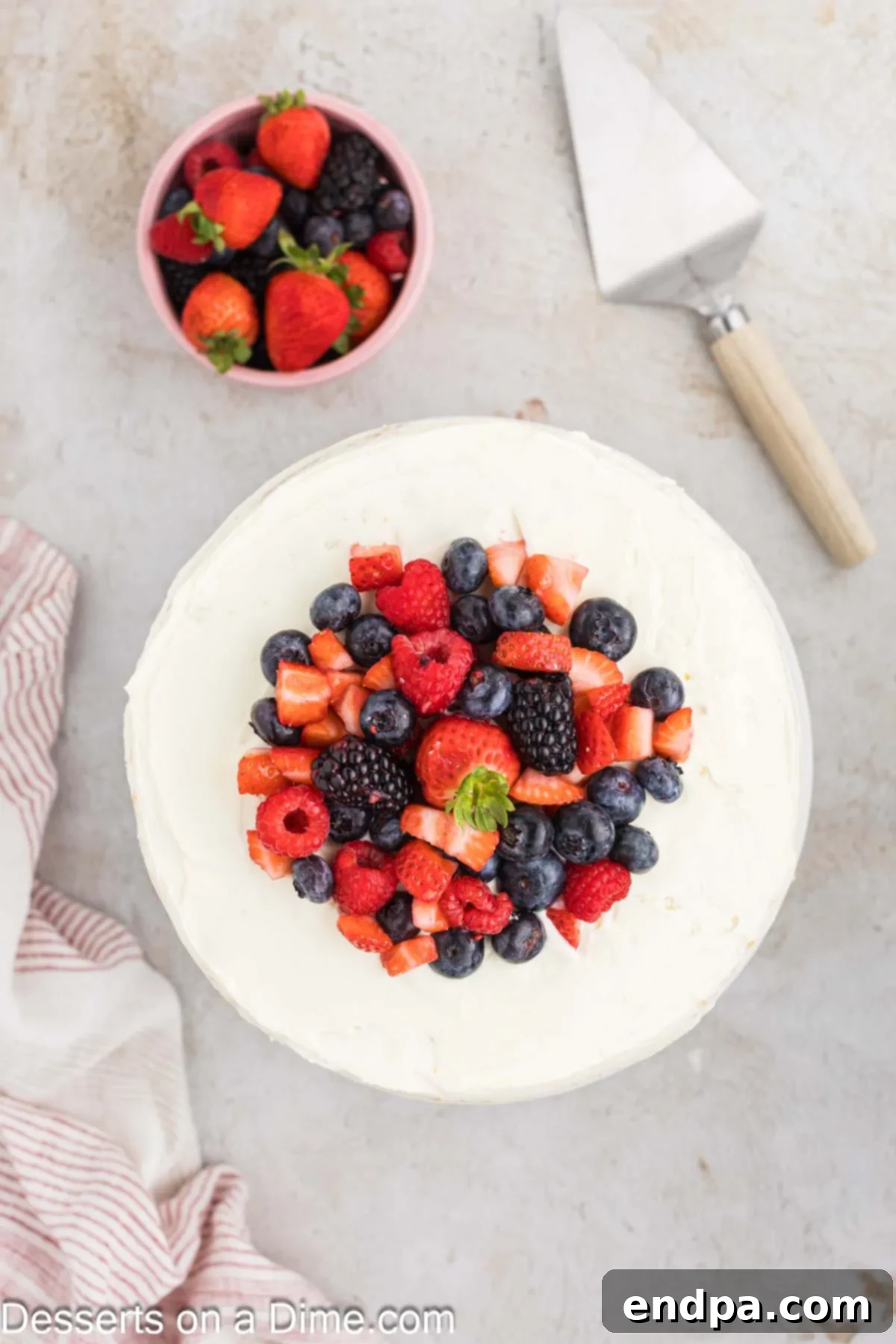The fully assembled Chantilly Cake, topped with remaining frosting and garnished with an abundance of fresh mixed berries.