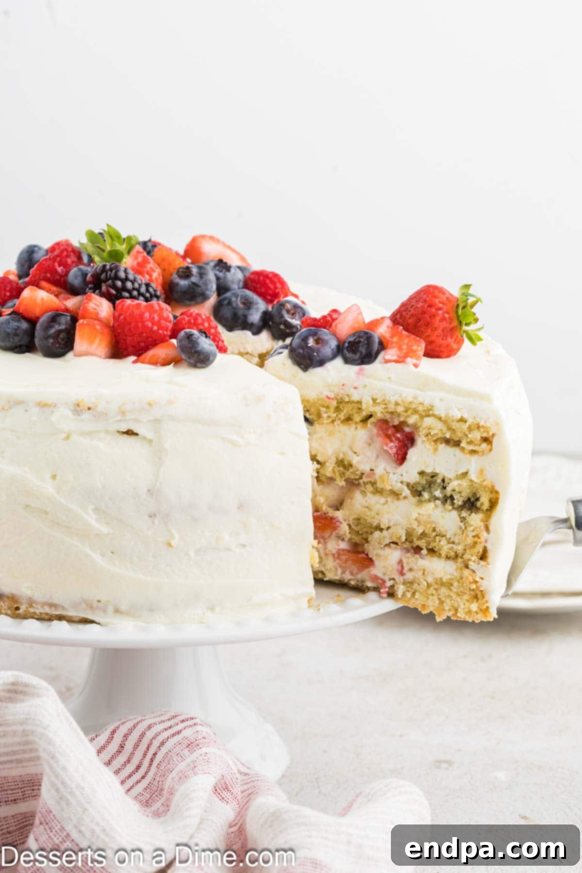 A slice of homemade Chantilly Cake being served, showcasing the beautiful layers and fresh berry filling.