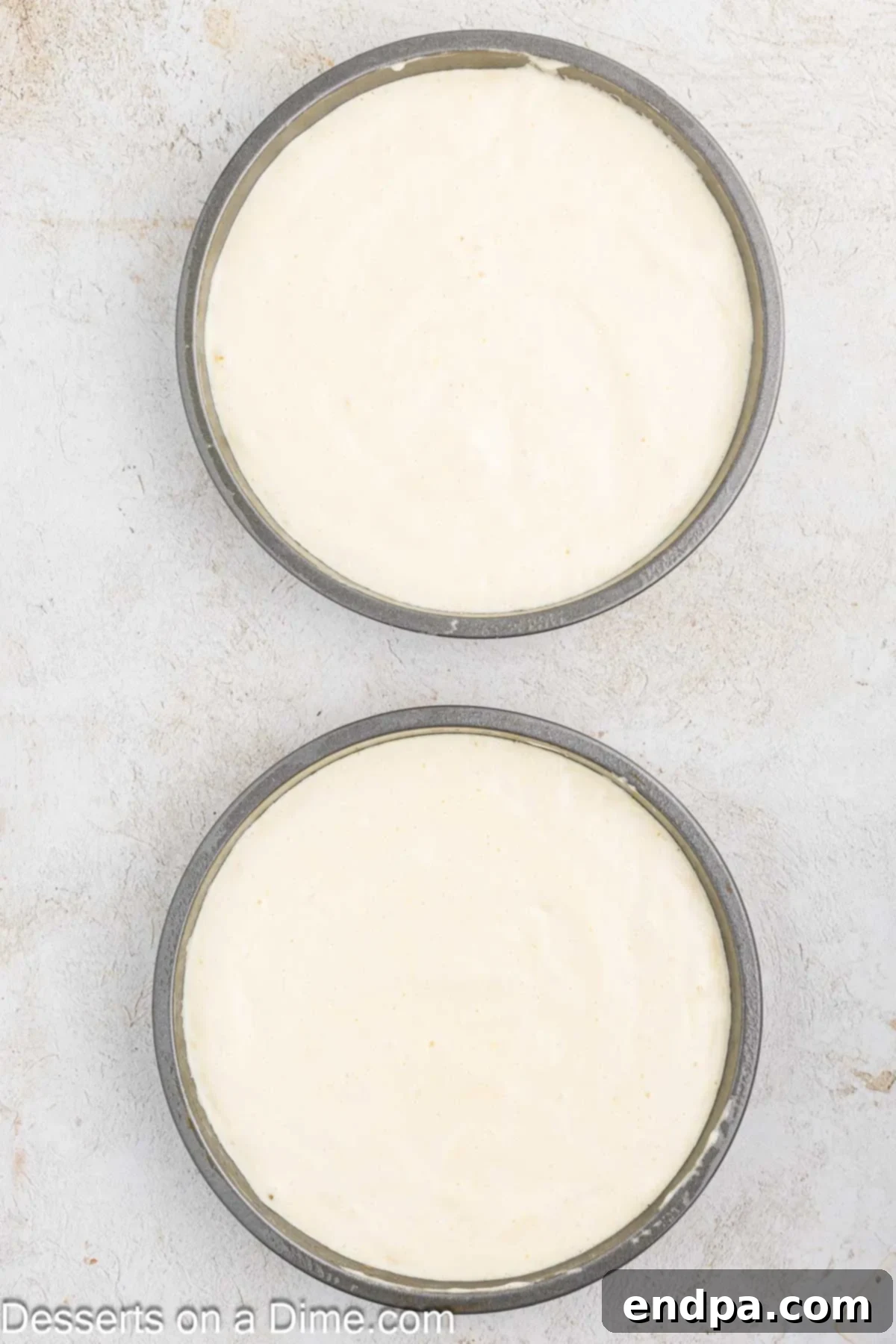 Cake batter evenly divided into two prepared round cake pans.