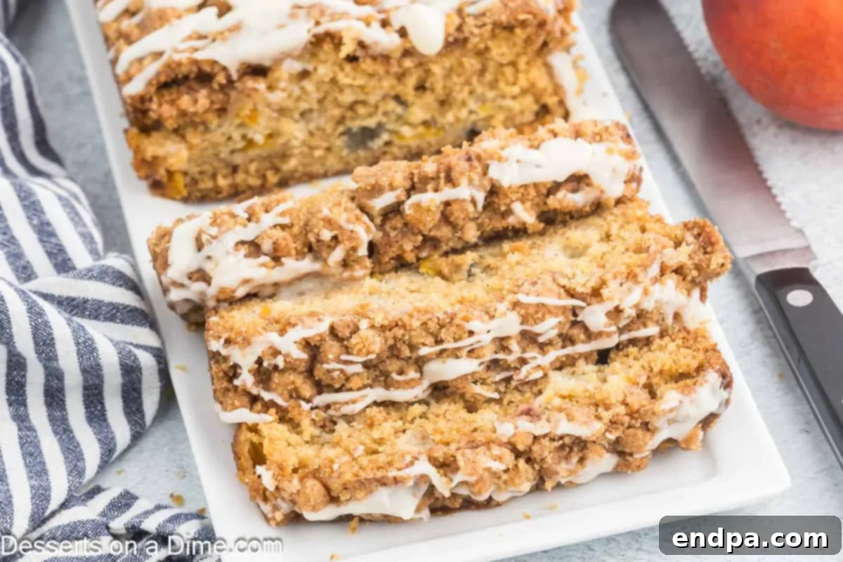 A beautiful loaf of Peach Bread, freshly sliced to reveal its moist interior with chunks of juicy peaches, resting on a pristine white platter.