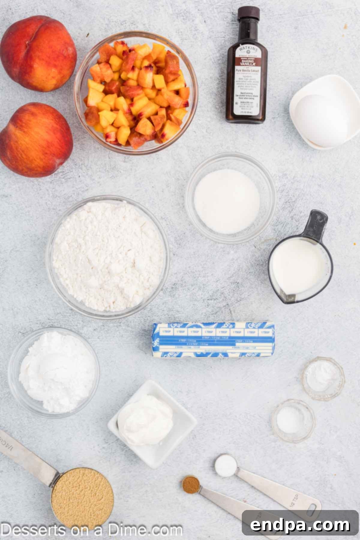 All essential ingredients for homemade peach bread arranged on a surface: flour, baking powder, baking soda, cinnamon, salt, butter, brown sugar, white sugar, egg, vanilla, sour cream, and a pile of fresh, diced peaches.