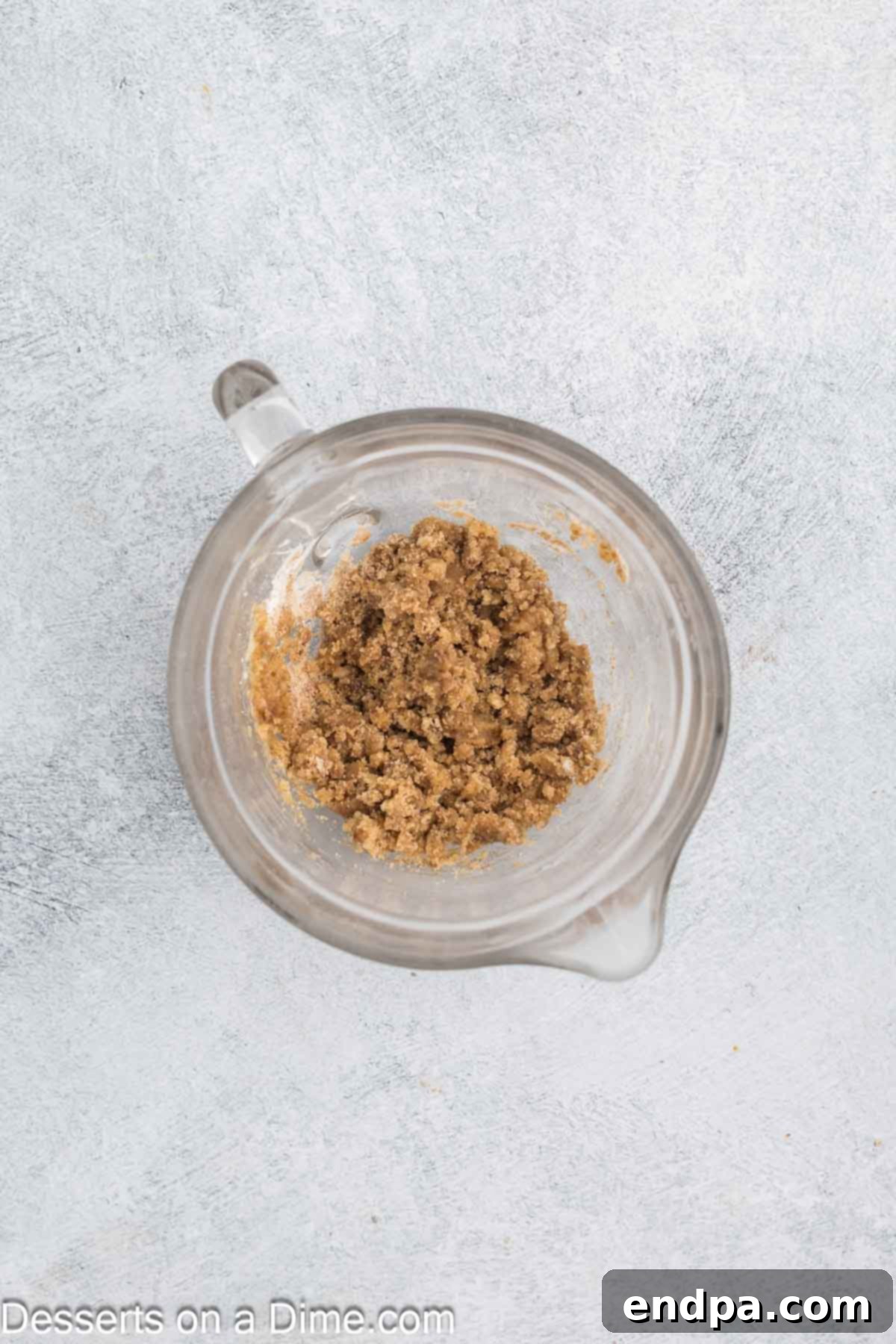 Streusel topping ingredients, including brown sugar, granulated sugar, cinnamon, melted butter, and flour, combined in a small bowl to form moist crumbs.