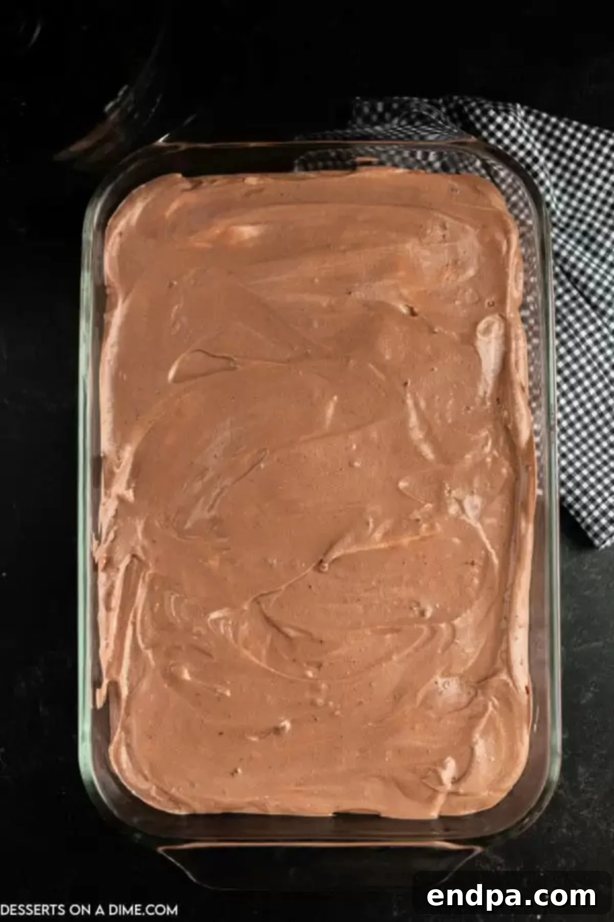 Chocolate pudding mixture spread evenly on top of the initial Oreo cookie layer in the baking dish.