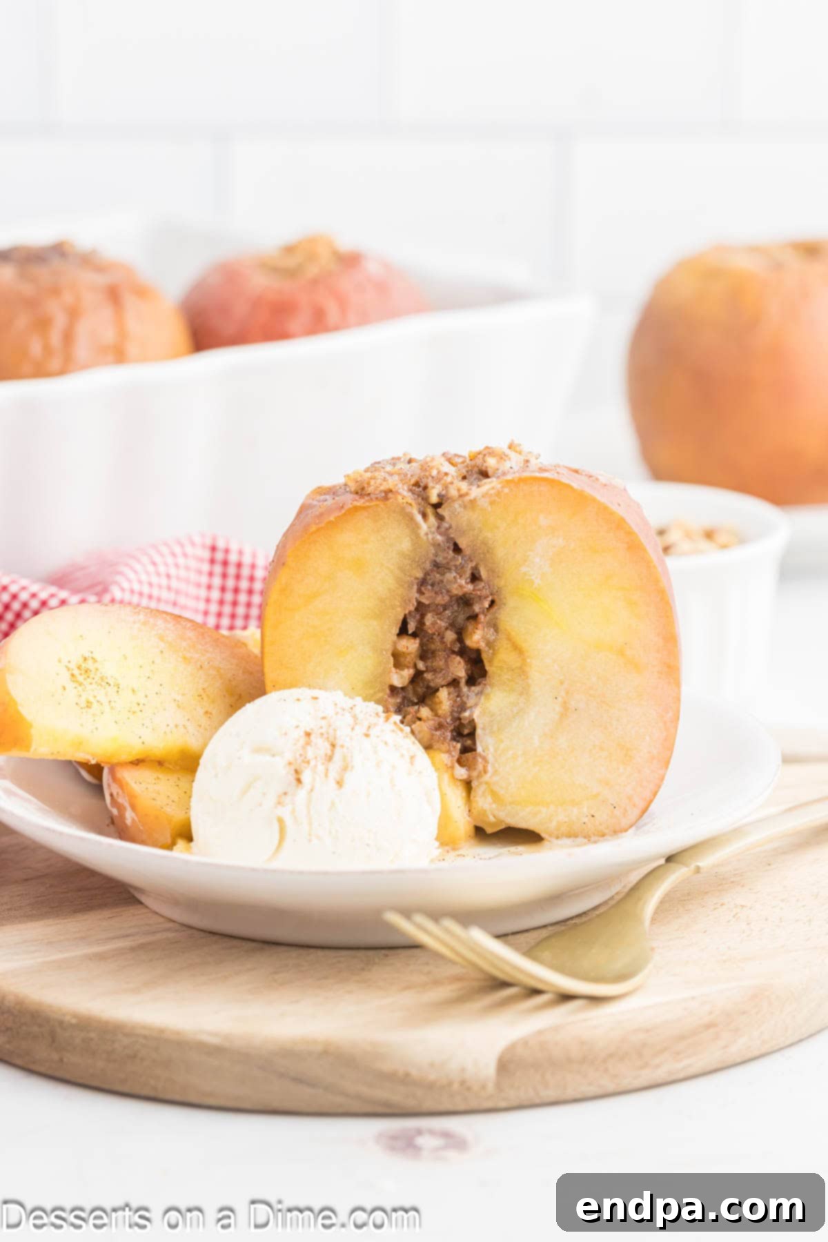 A single baked apple, perfectly golden and tender, topped with a generous scoop of melting vanilla ice cream, served on a white plate.