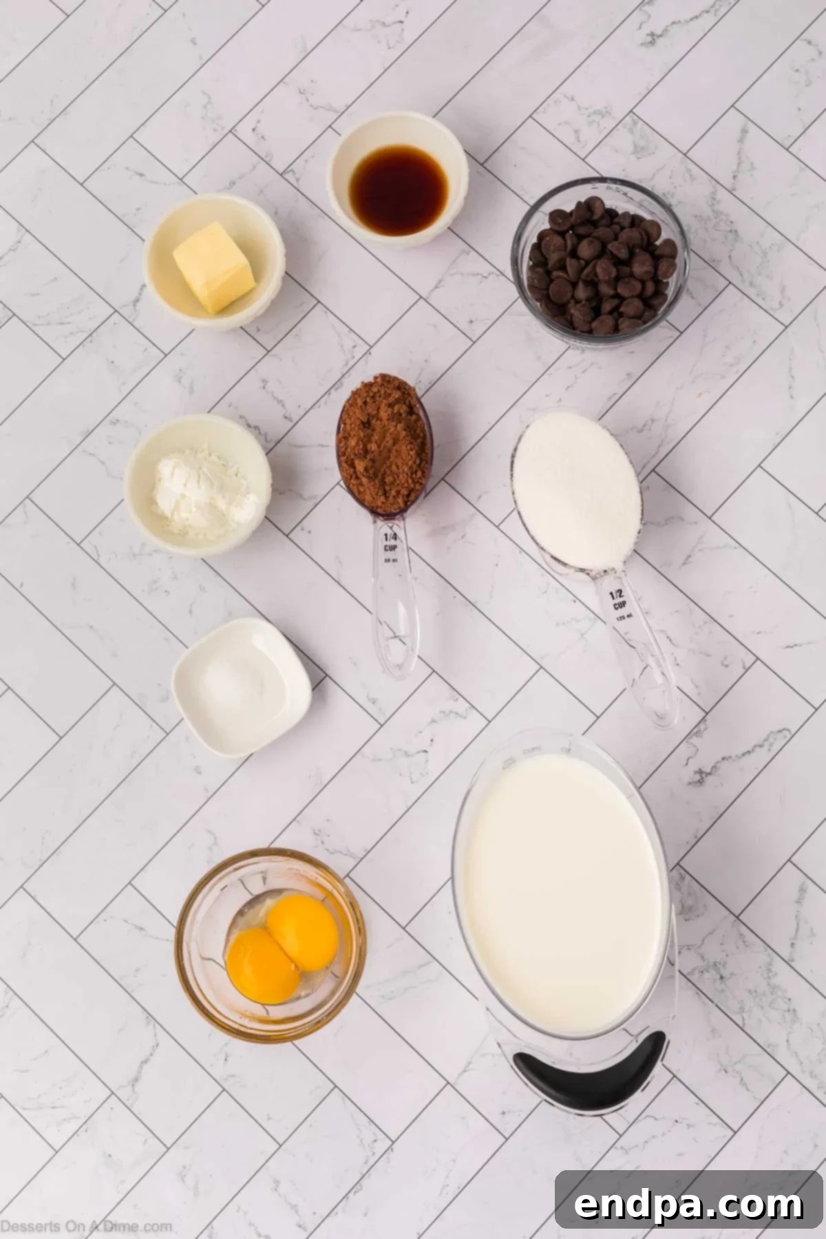 Velvety Dark Chocolate Pudding 3 Various ingredients for dark chocolate pudding, including egg yolks, whole milk, granulated sugar, cocoa powder, cornstarch, salt, vanilla extract, dark chocolate chips, and butter, neatly arranged on a counter.