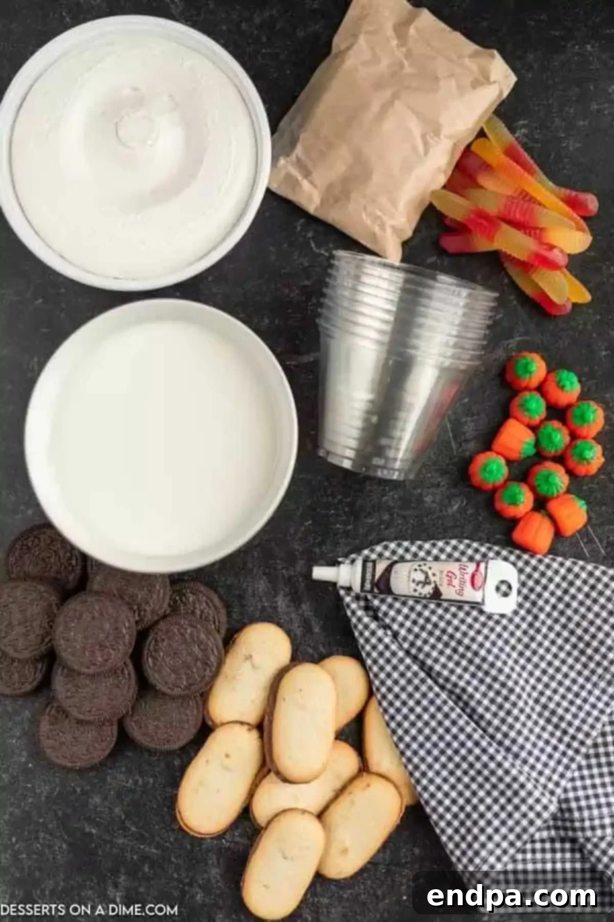 Ingredients for Halloween dirt cups including cool whip, gummy worms, candy pumpkins, Oreo cookies, milk, and instant chocolate pudding mix.