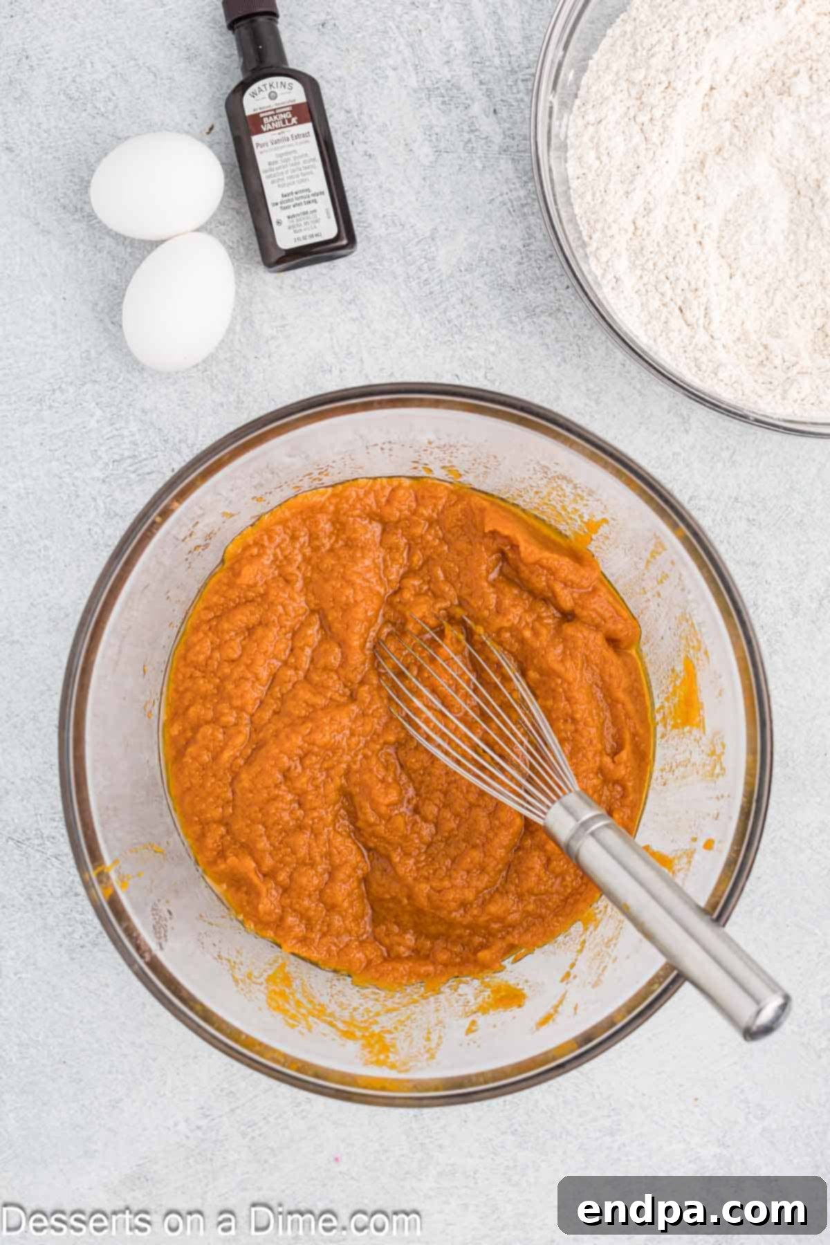 Autumn Pumpkin Cream Pies 4 A bowl containing a smoothly mixed pumpkin puree, sugar, and oil mixture, showcasing a uniform and vibrant orange base ready for the next stages of whoopie pie batter preparation.