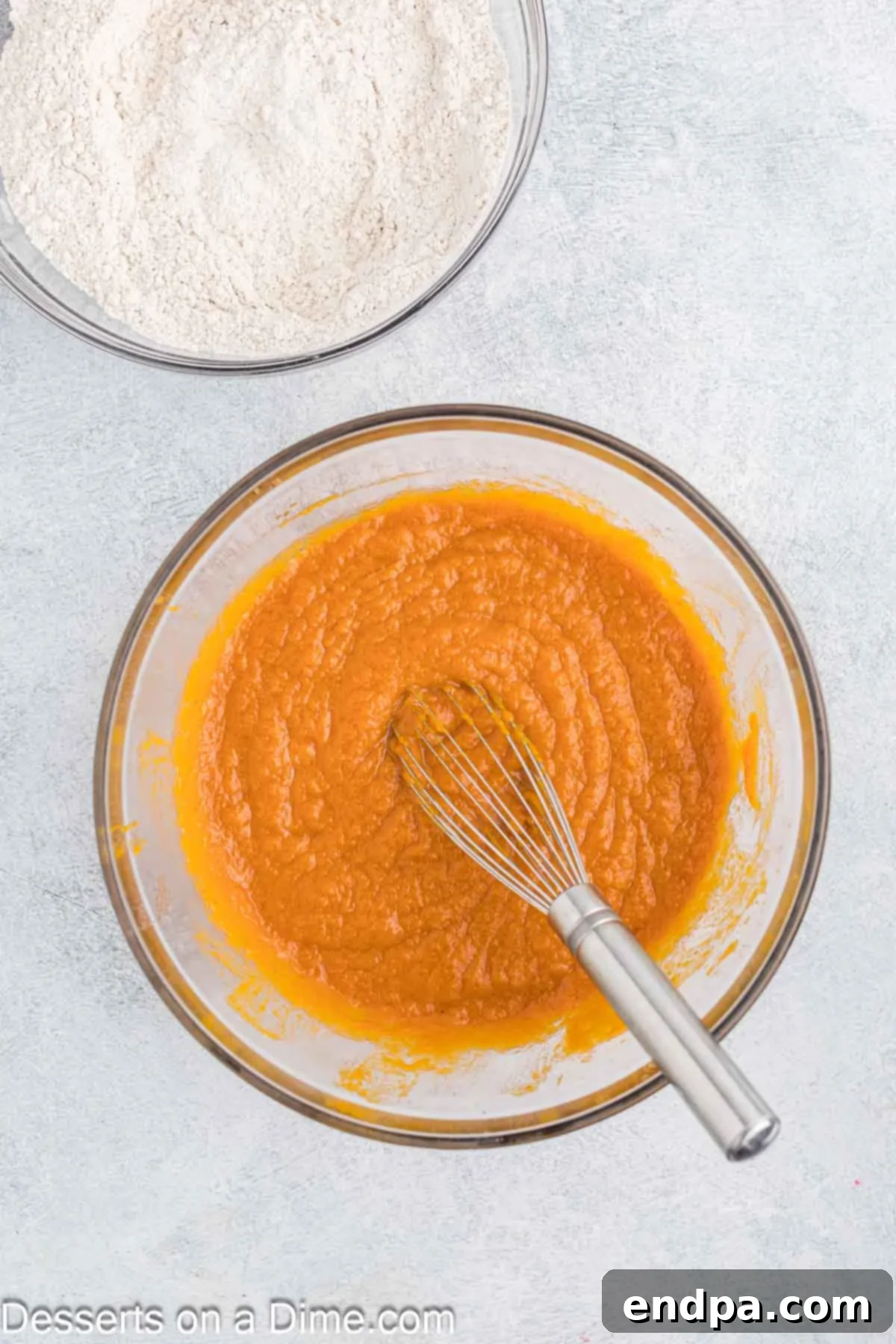 Autumn Pumpkin Cream Pies 5 A mixing bowl holding the pumpkin mixture, now perfectly combined with vanilla extract and eggs, stirred until smooth and consistent, indicating a well-emulsified batter.