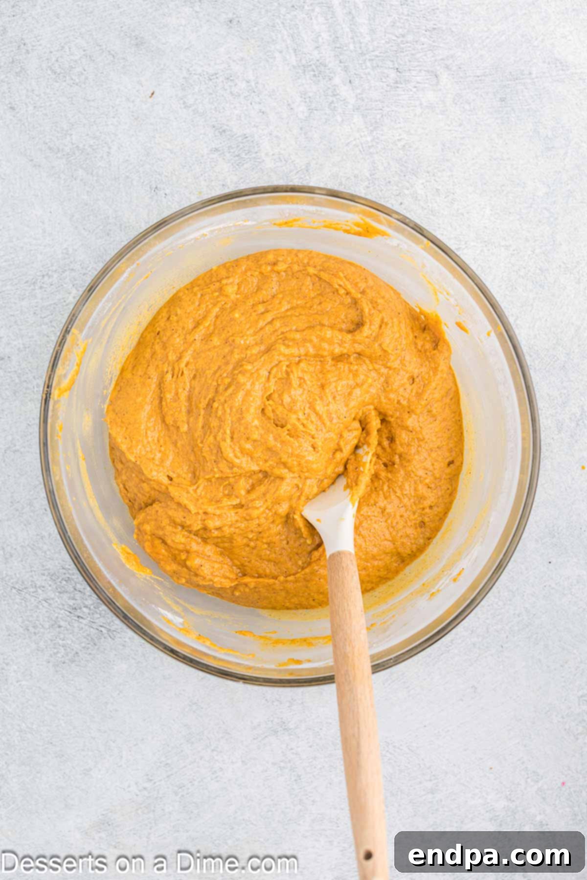 Autumn Pumpkin Cream Pies 6 A close-up of the wet and dry ingredients for pumpkin whoopie pies being carefully folded together in a mixing bowl, emphasizing the importance of gentle mixing to achieve a tender crumb.