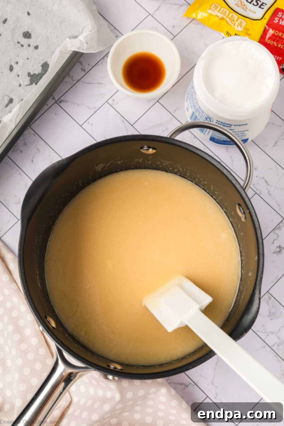 Butter, sugar, and evaporated milk simmering in a saucepan over medium heat.