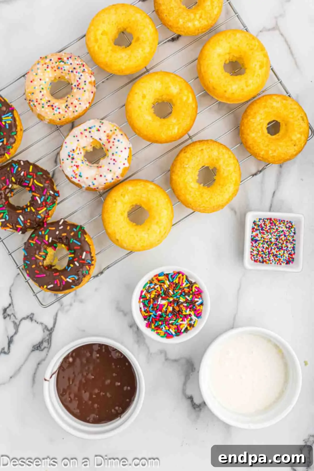 Donuts with glaze and sprinkles on wire rack.