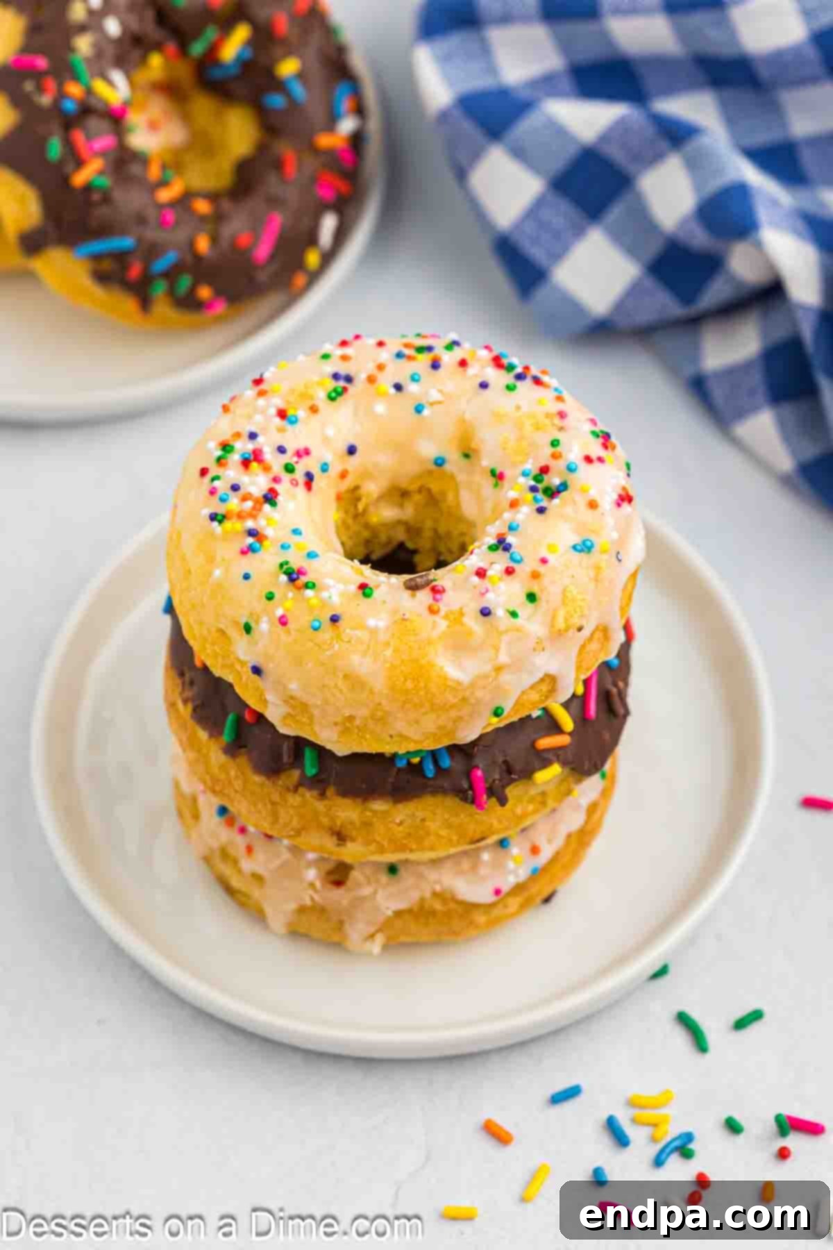 Cake Donuts with sprinkles stacked on a plate.