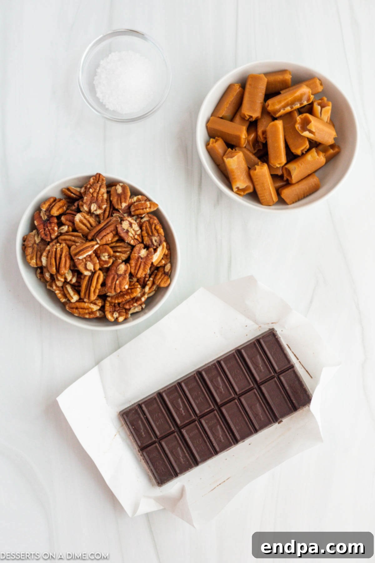 Ingredients for recipe - pecans, caramels, heavy whipping cream, semi-sweet melting chocolate, sea salt.
