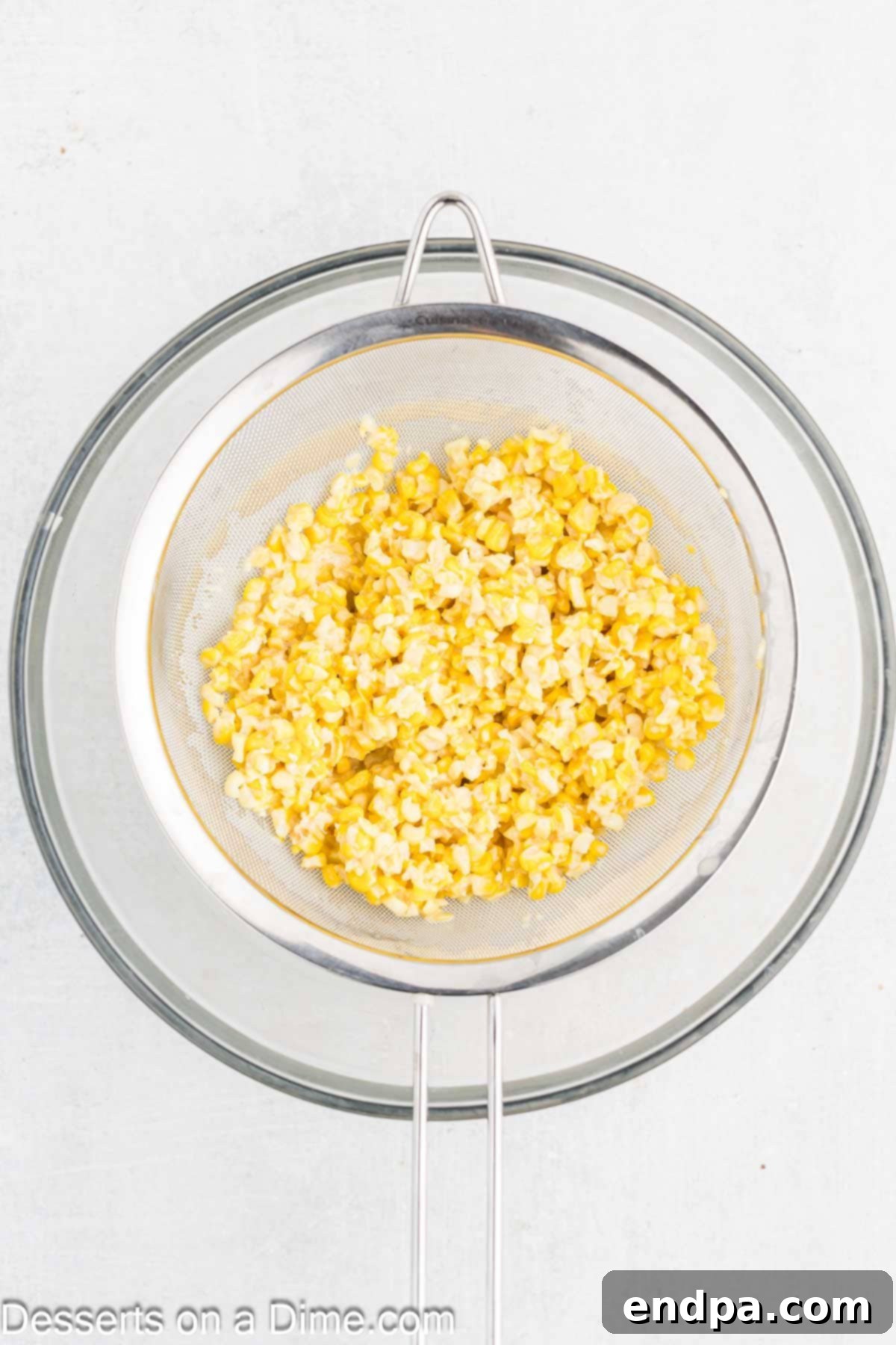 Straining the corn mixture through a fine-mesh sieve.