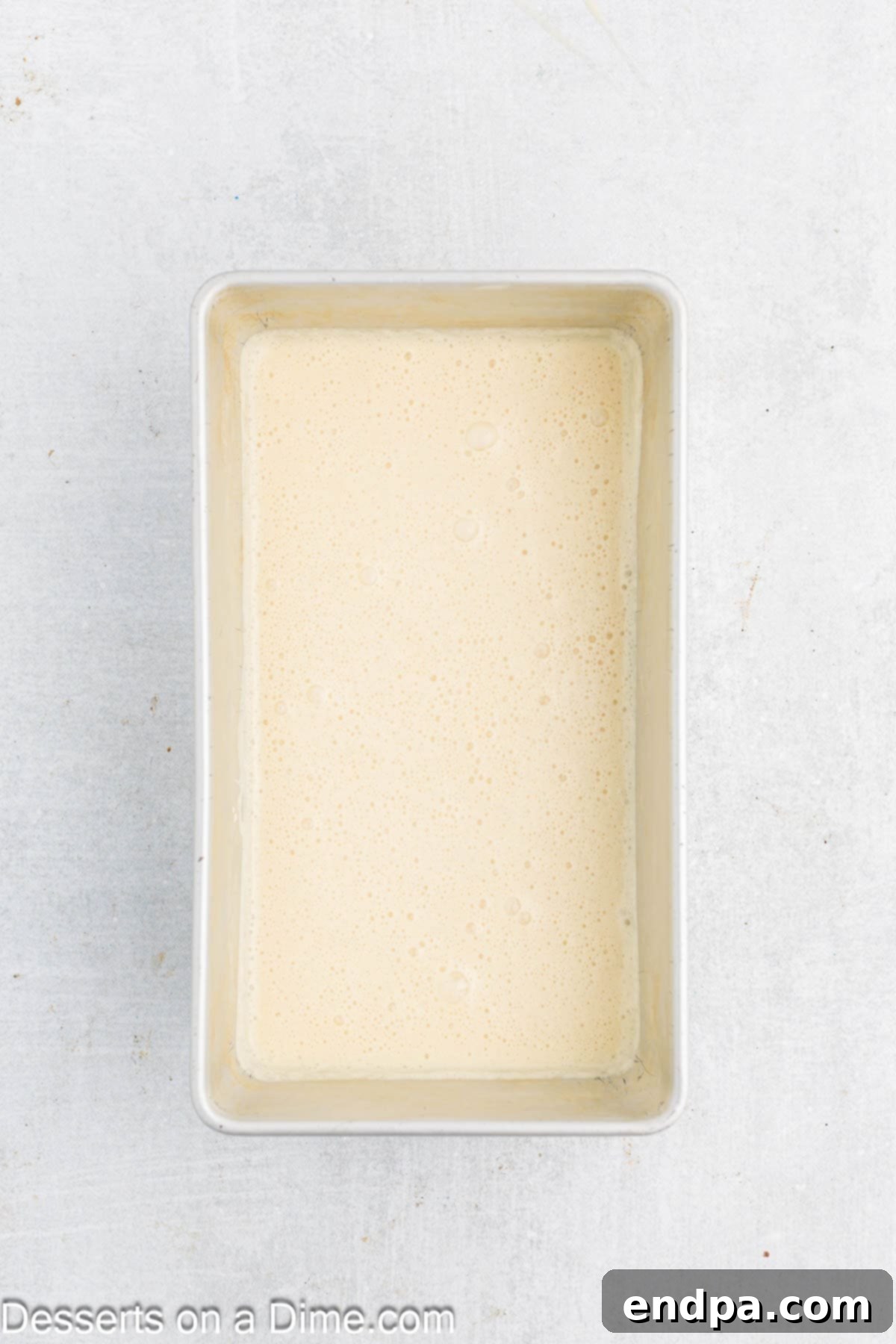 Aerated ice cream mixture poured into a loaf pan, ready for freezing.