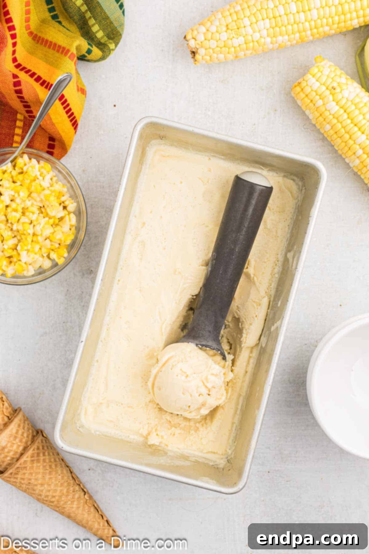 Frozen corn ice cream being scooped into a bowl.