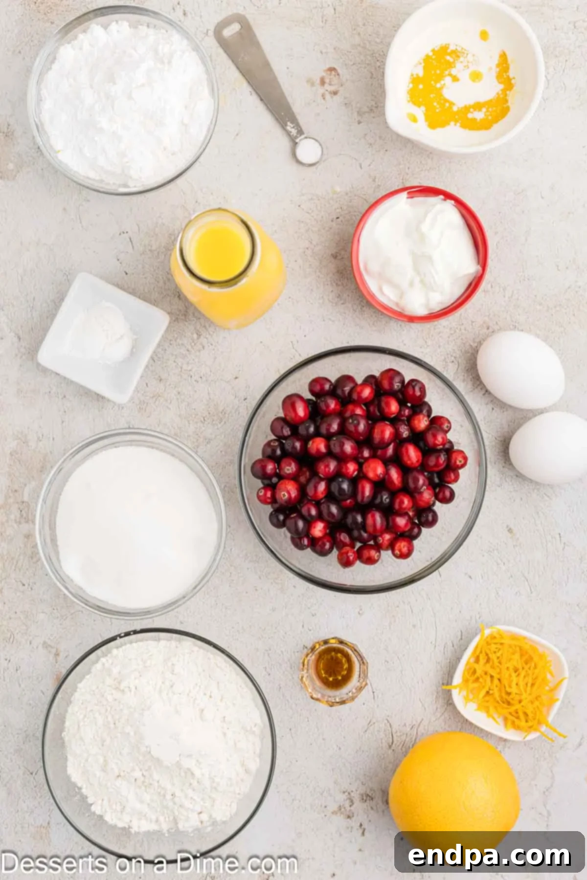 Ingredients for homemade orange cranberry bread including Greek yogurt, melted butter, fresh orange juice and zest, eggs, granulated sugar, all-purpose flour, baking powder, salt, and fresh cranberries.