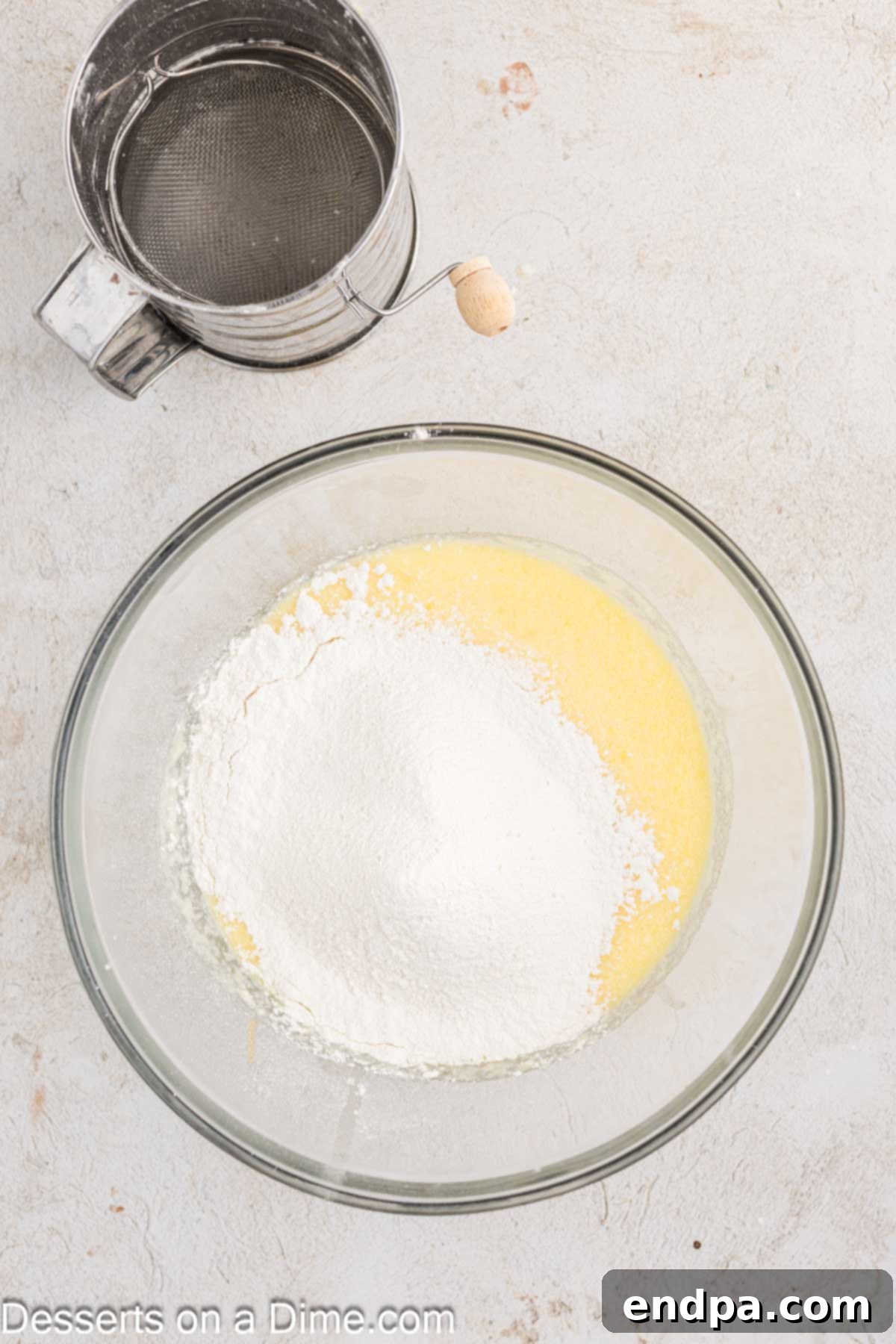 Dry ingredients for orange cranberry bread being sifted into the bowl of wet ingredients, consisting of flour, baking powder, and salt.