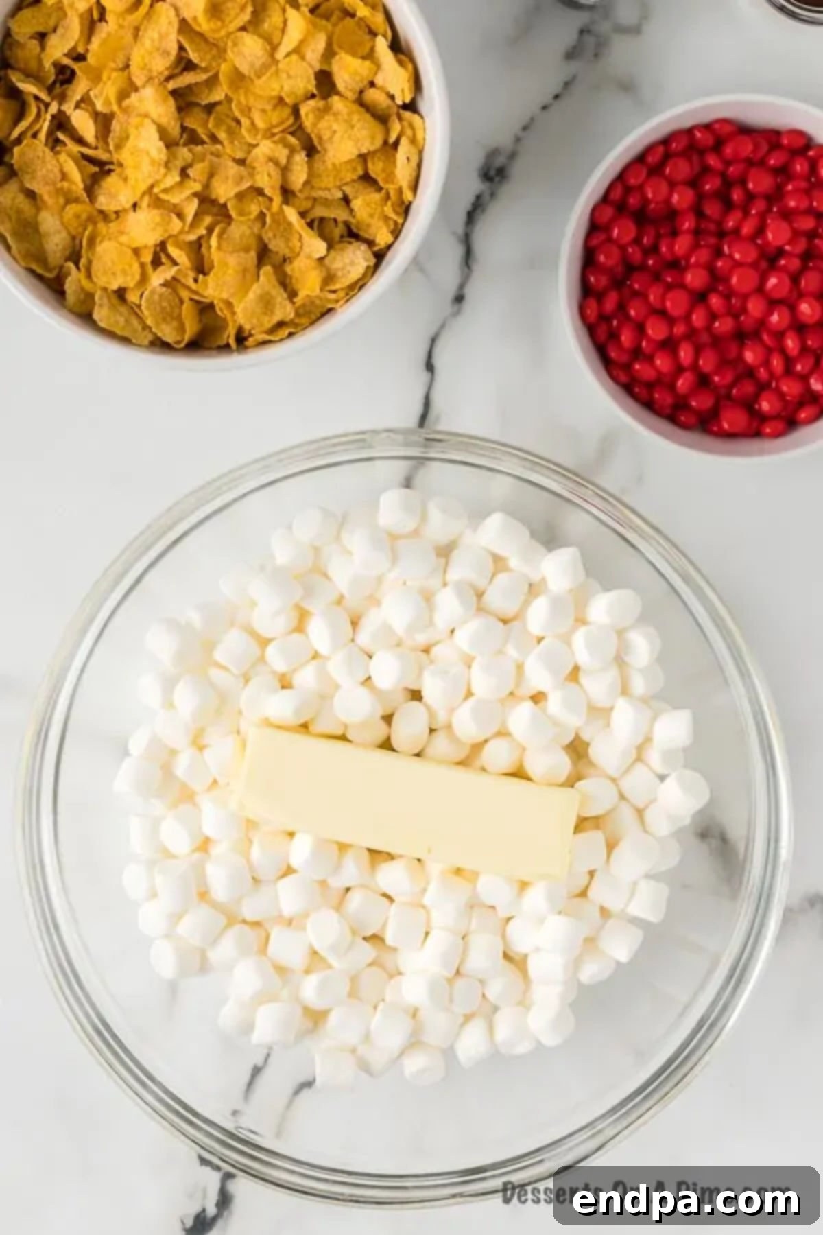 A microwave-safe bowl containing mini marshmallows and butter, prepared for melting.