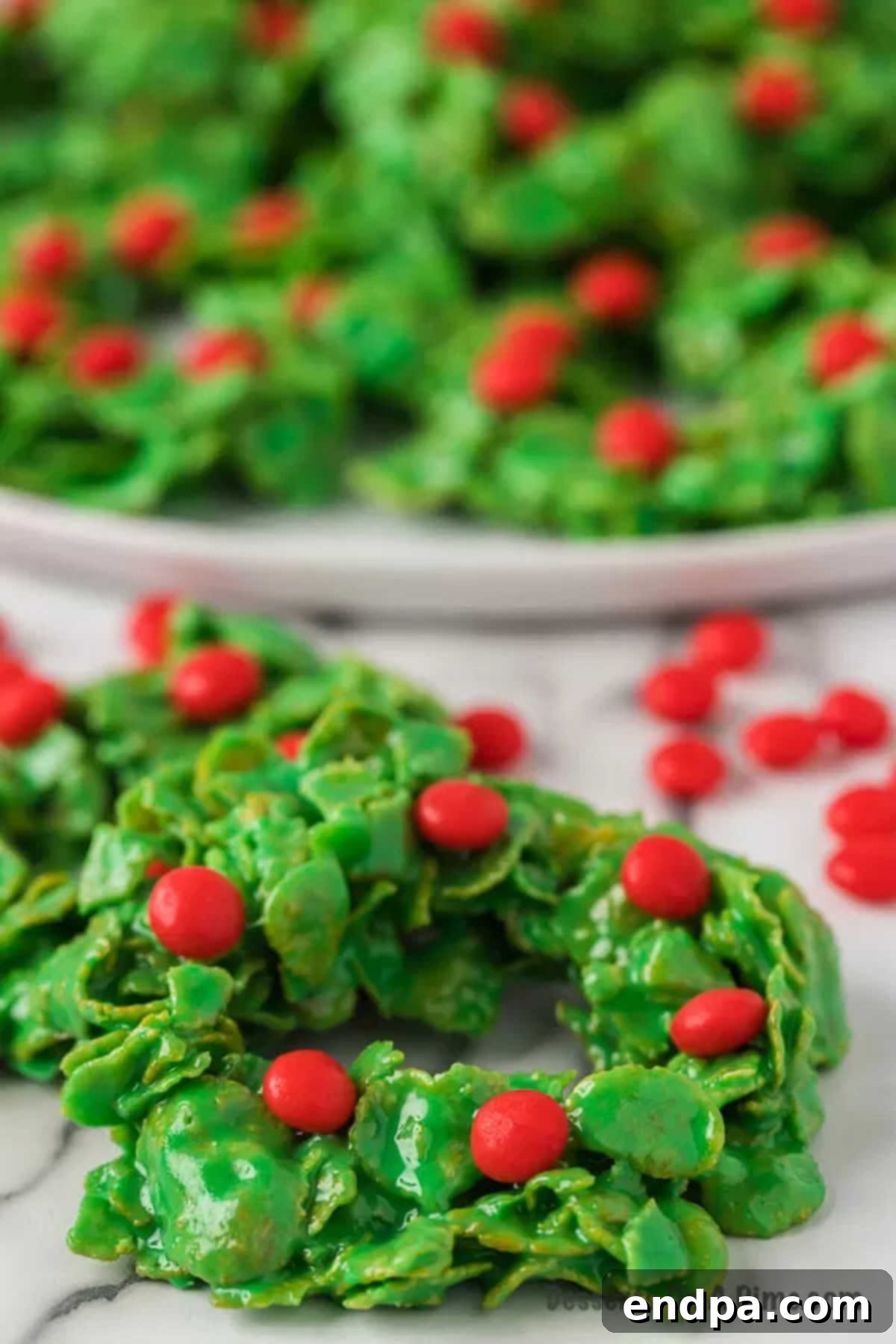 A vibrant platter brimming with numerous homemade Christmas wreath cookies, perfectly decorated and ready for festive serving.