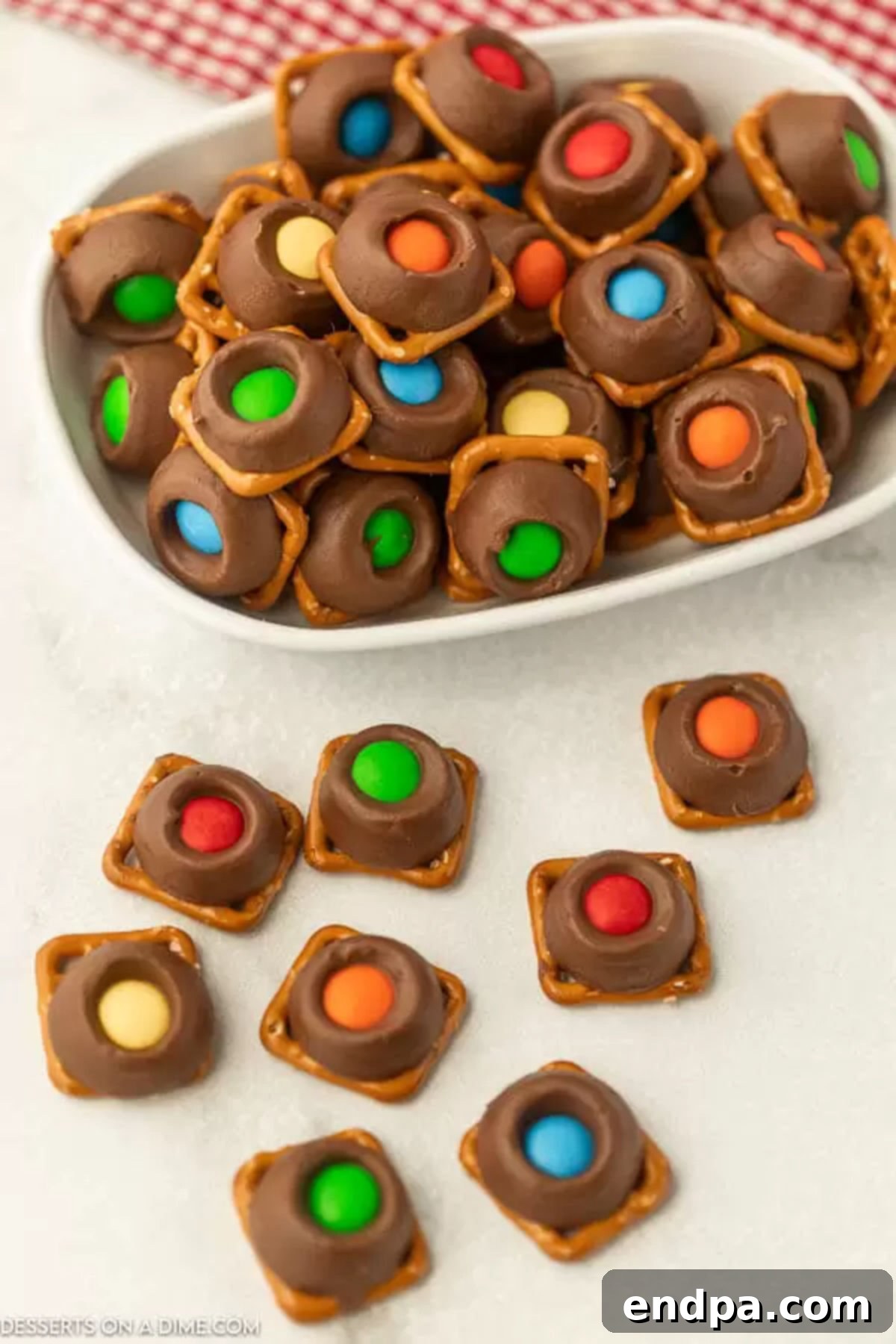 A bowl filled with finished Rolo Pretzel Bites, showcasing their chocolate, caramel, and pretzel layers, topped with colorful M&Ms.